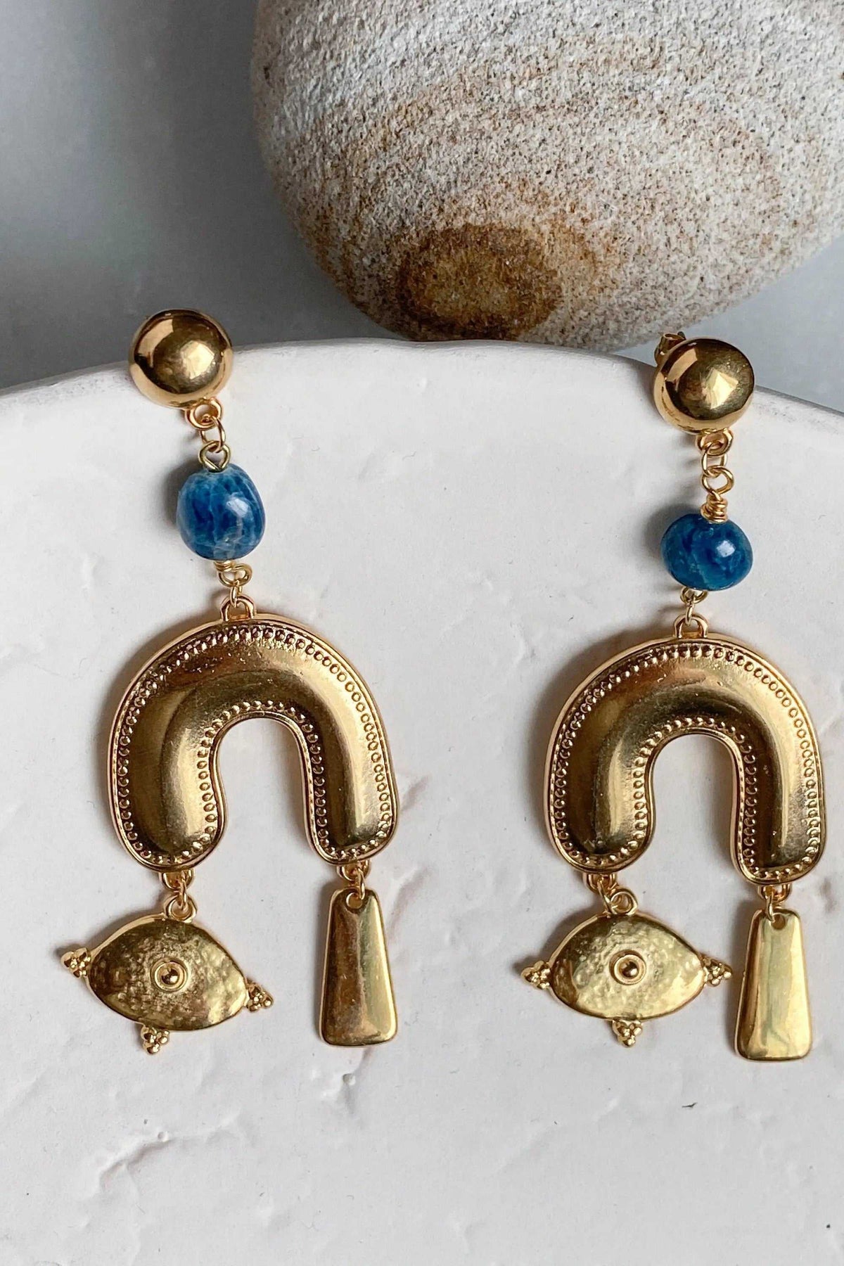 Gold Gypsy Earrings in gold-tone metal with blue stones, featuring ornate horseshoe shapes and dangling charms