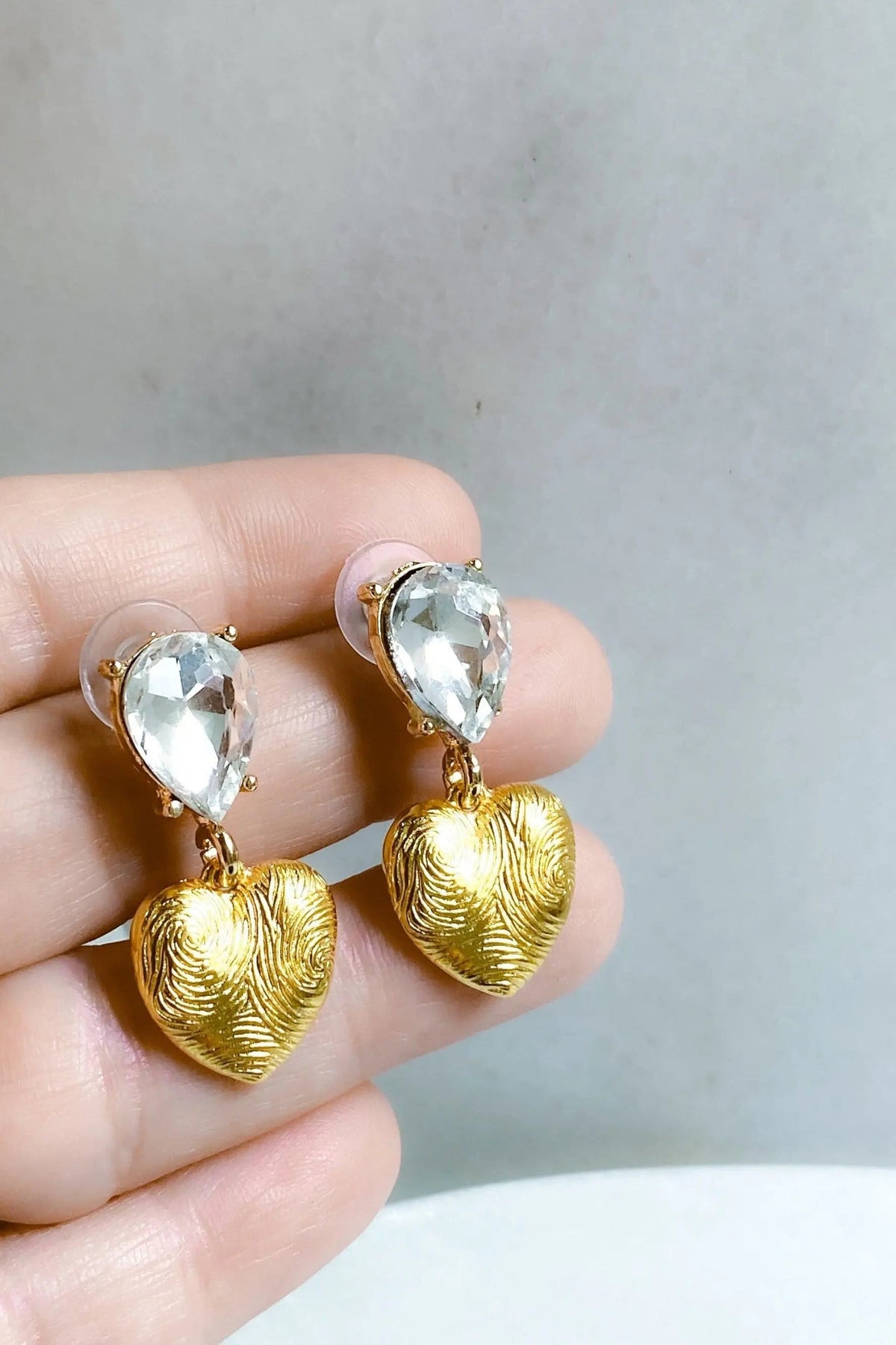 Gold Heart Earrings with textured gold-tone heart pendants and clear faceted teardrop crystals above