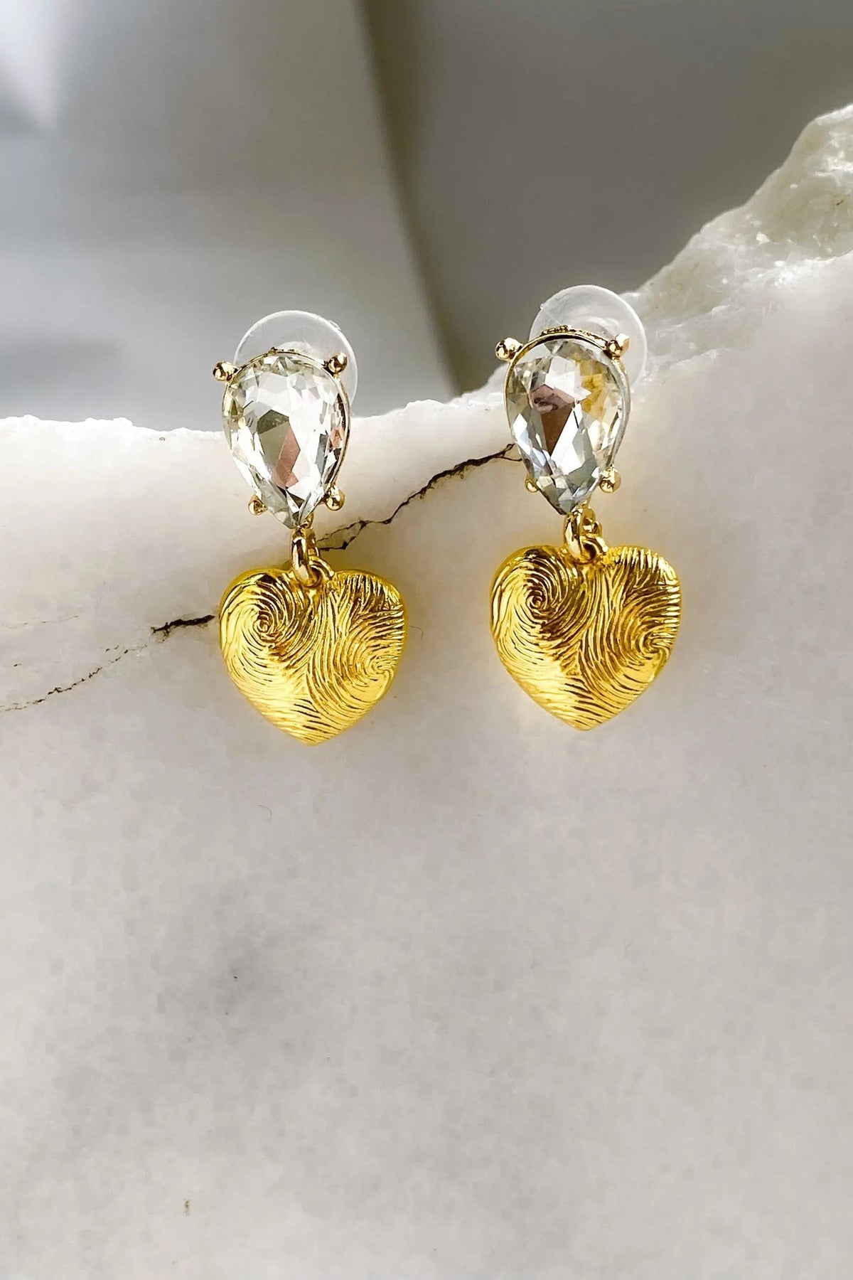 Gold Heart Earrings with textured gold-tone heart charms and clear teardrop crystals in a dangling design