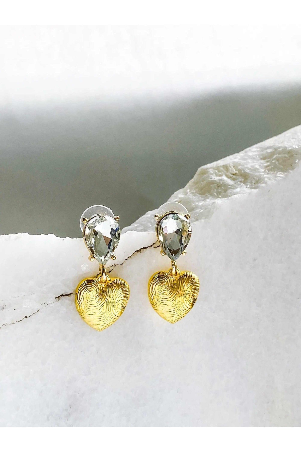 Gold Heart Earrings with textured gold heart pendants and clear teardrop-shaped crystal studs