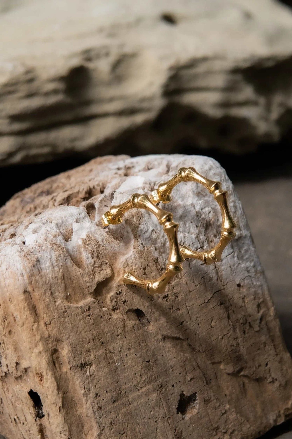 Gold hoop earrings with a polished gold finish, featuring an organic bamboo-inspired design with raised knuckle details.