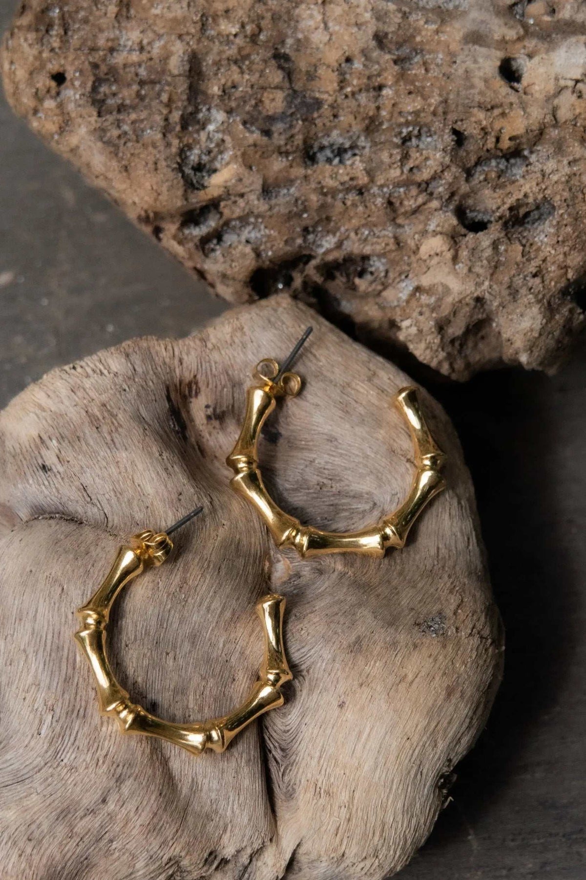 Gold hoop earrings with a glossy gold-tone finish, sculpted bamboo-like segments and straight posts with butterfly backs