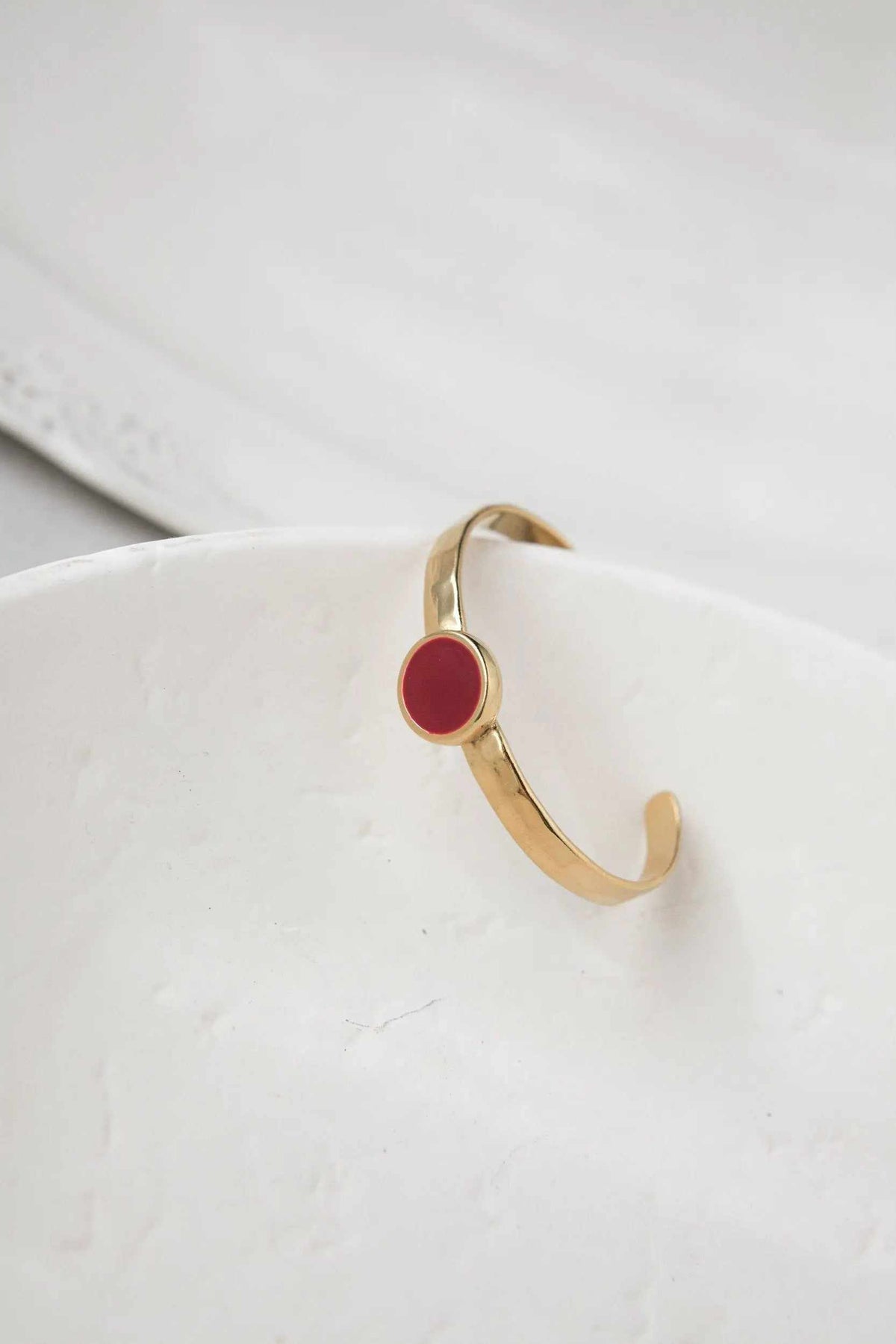 Gold plated Hammered bracelet with a polished gold-tone band and a round red enamel centerpiece