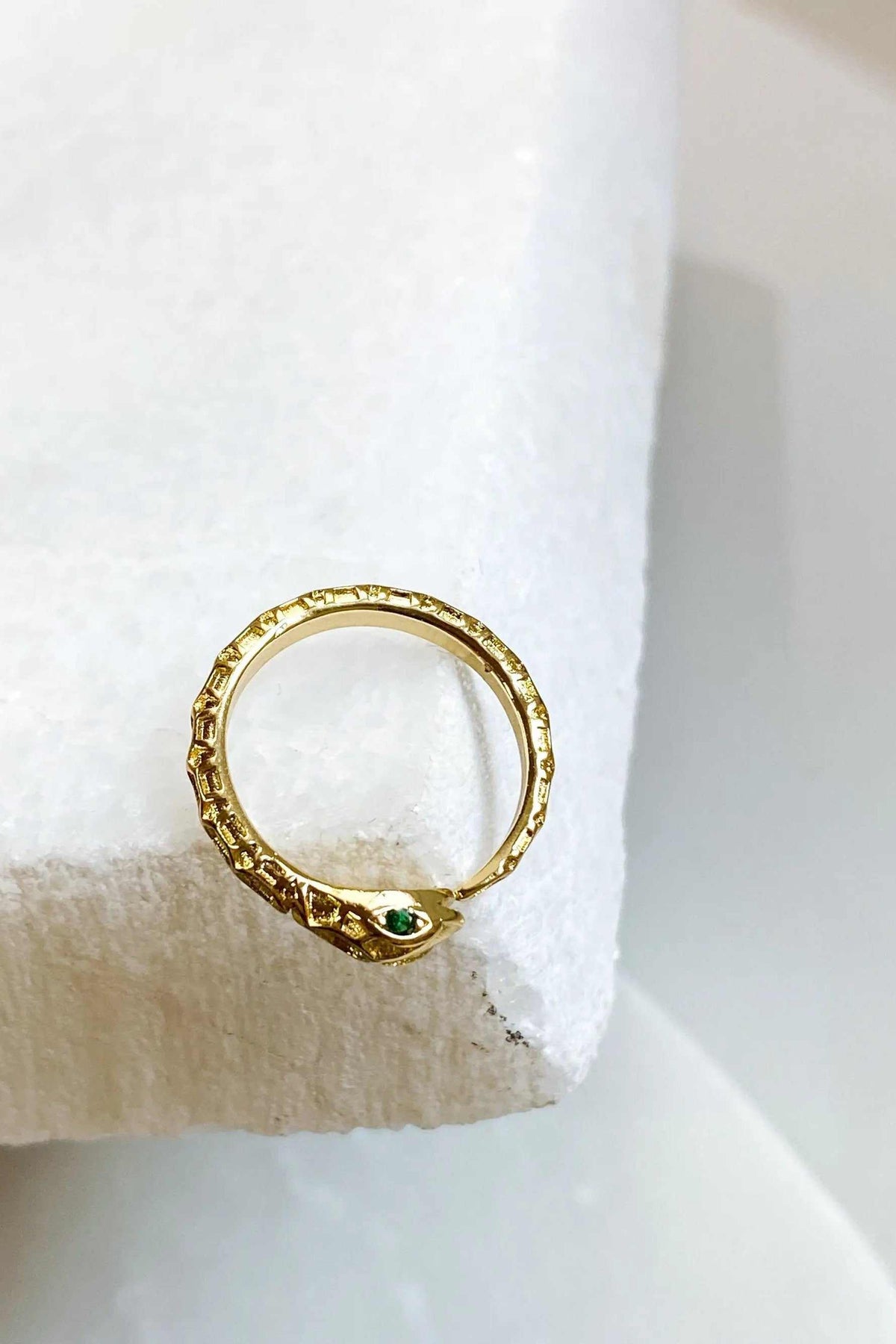 Gold Snake RING with a textured gold-tone serpent band and small green eye stones