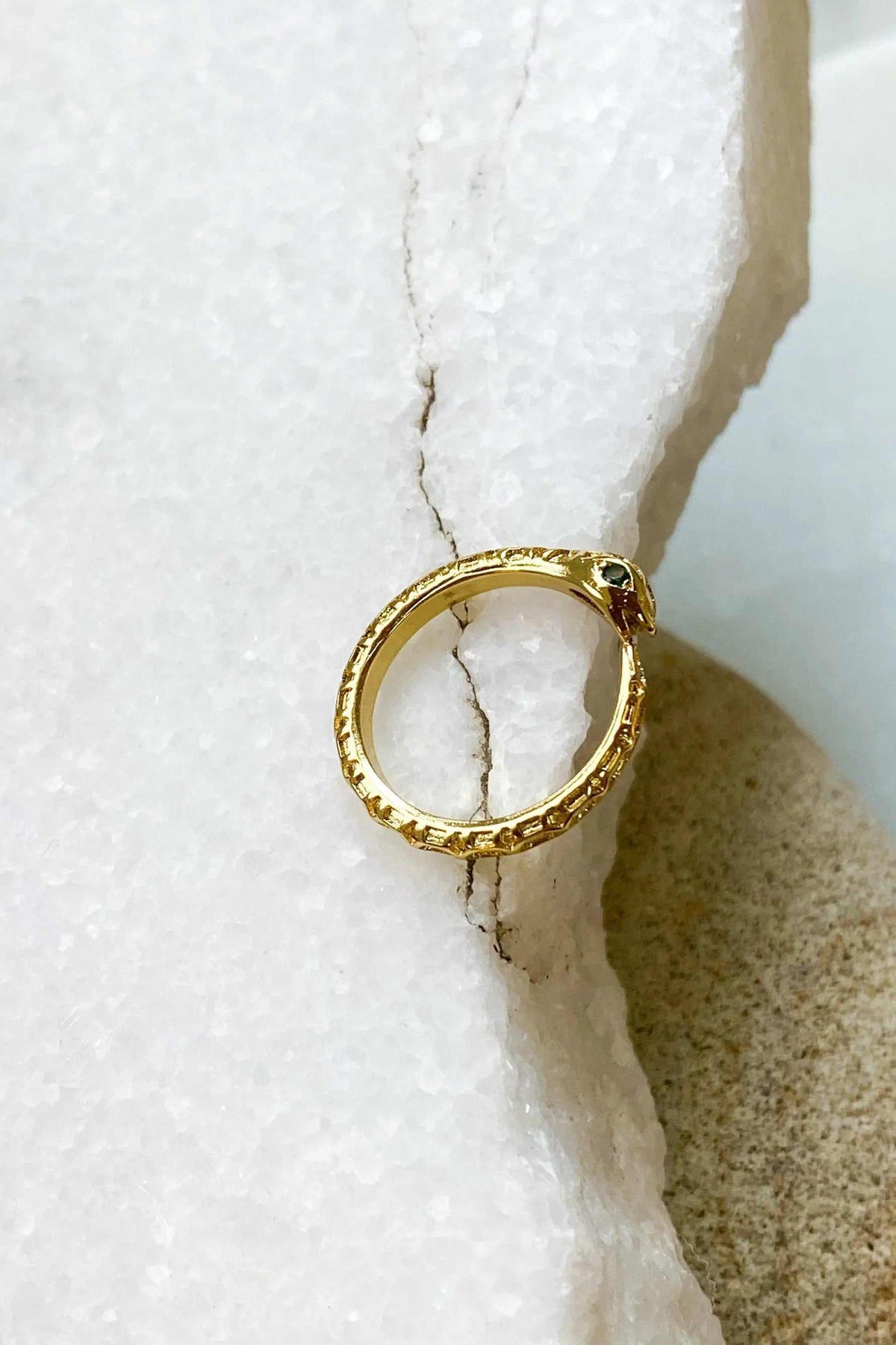 Gold Snake RING in textured gold-tone metal, with a slim circular band and a small dark green stone accent.