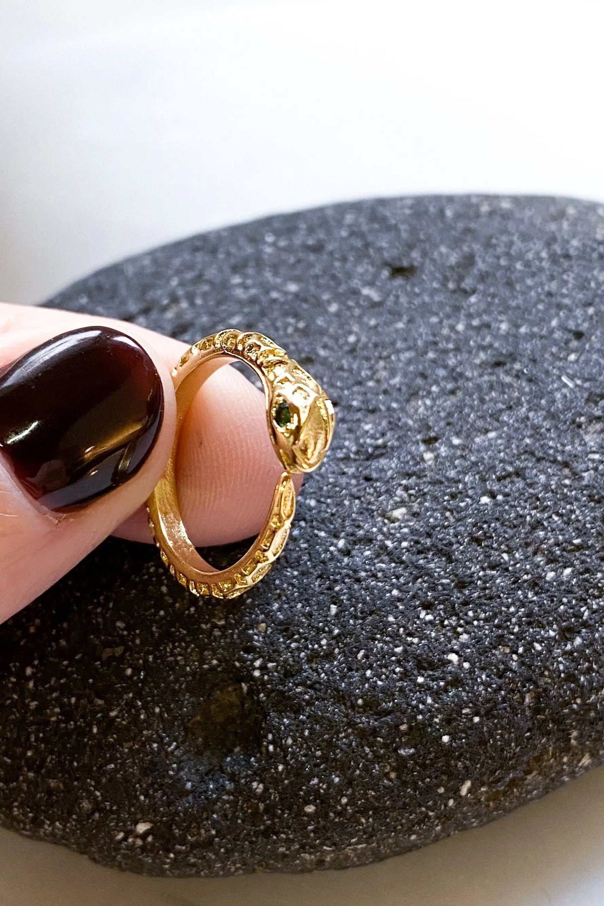 Gold Snake RING in polished gold-tone metal, featuring a textured serpent design with a small green accent stone.