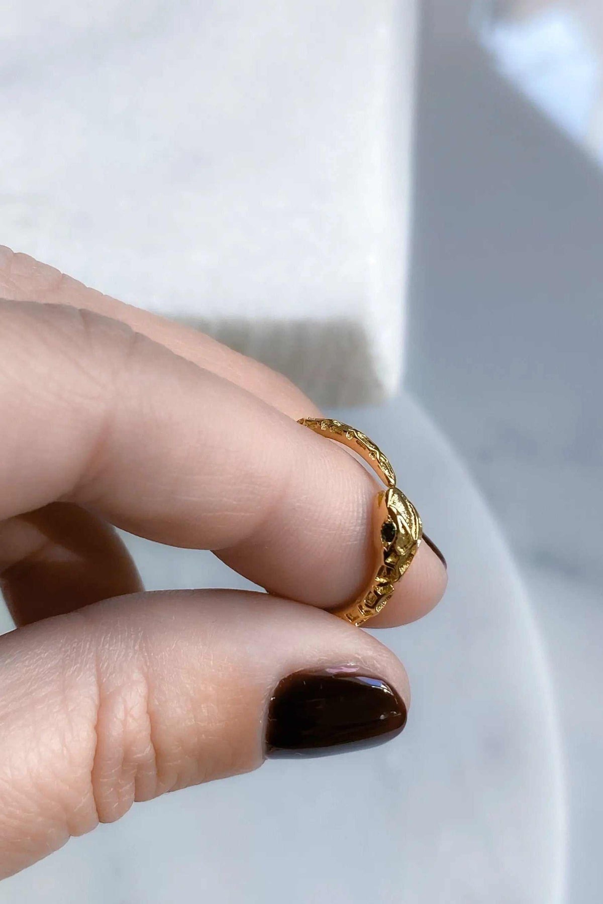Gold Snake RING with a textured gold-tone serpent design and small dark green details, worn on a finger