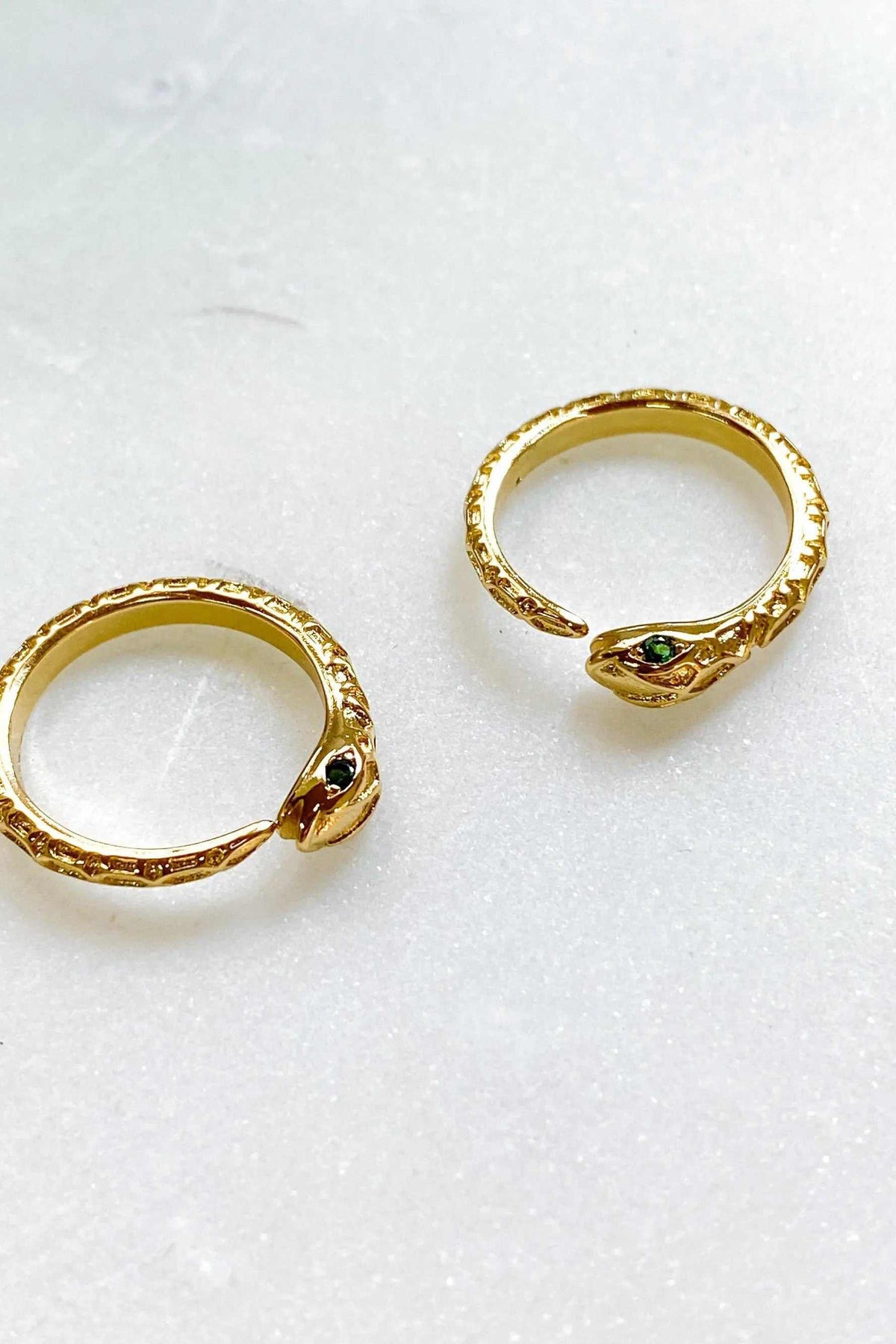 Gold Snake RING with a textured gold-tone serpent design and small green eyes, shown as two matching bands
