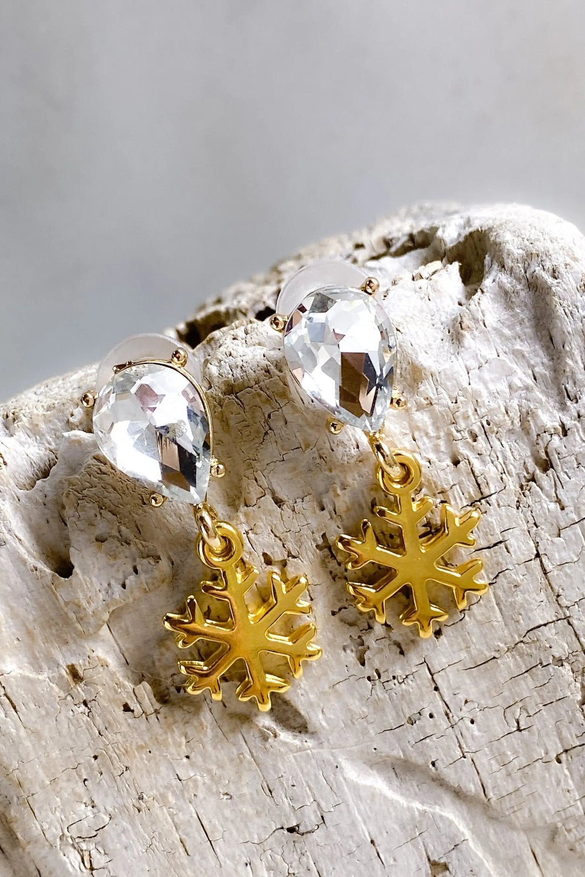 Gold Snowflake Earrings with polished gold-tone snowflake charms and clear faceted teardrop crystals above.