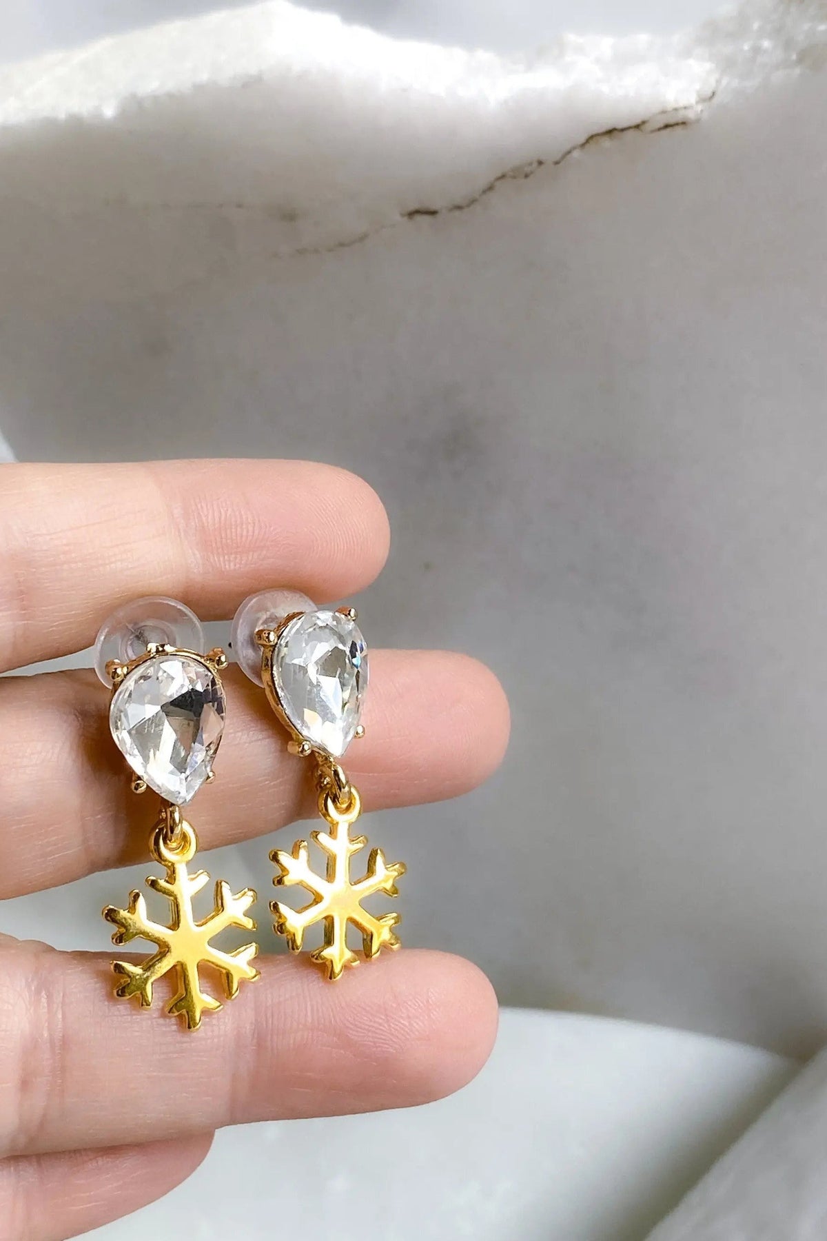 Gold Snowflake Earrings with gold-tone snowflake charms and clear faceted teardrop crystals in a dangling design