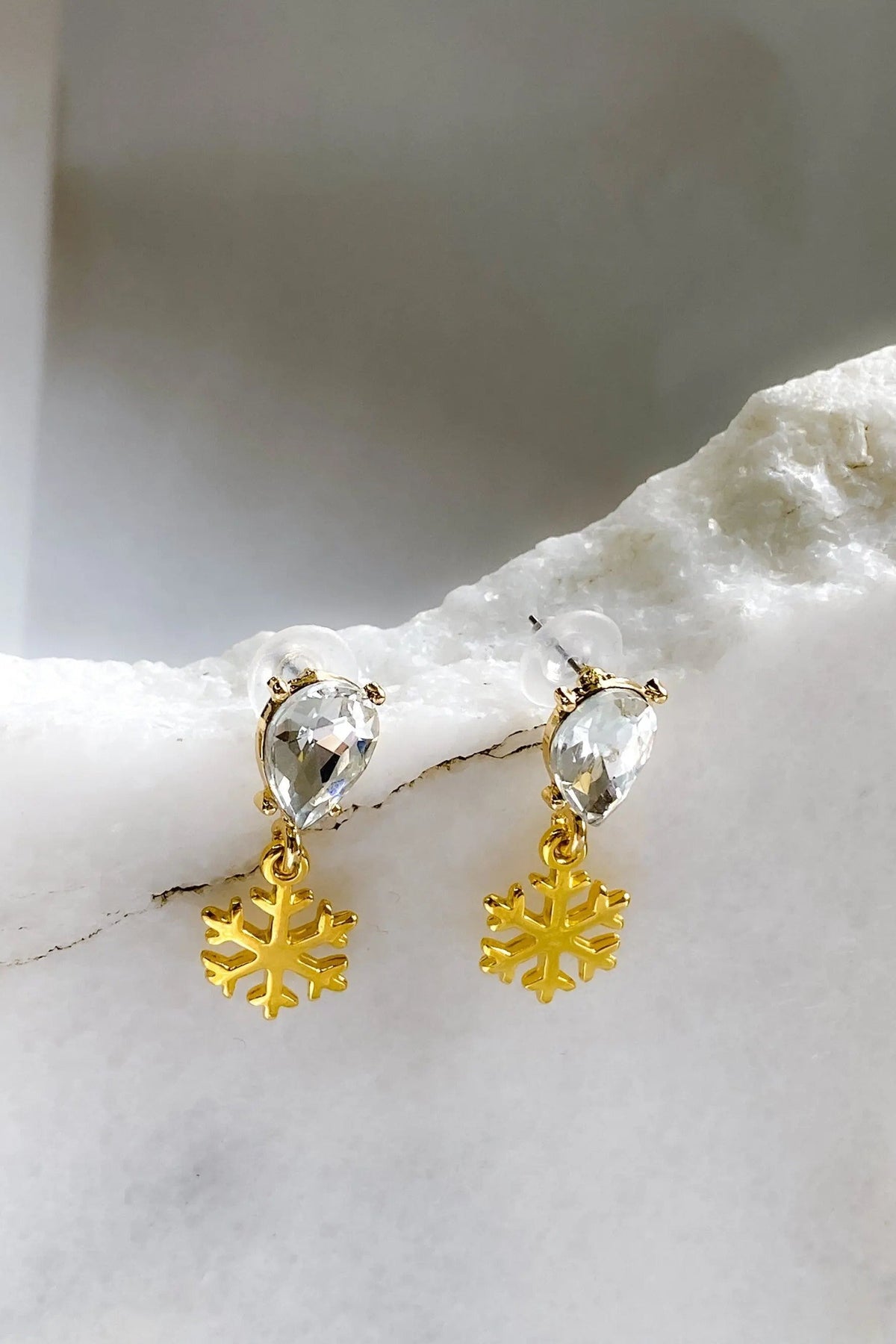 Gold Snowflake Earrings with gold-tone snowflake charms and clear faceted teardrop crystals in a dangling design