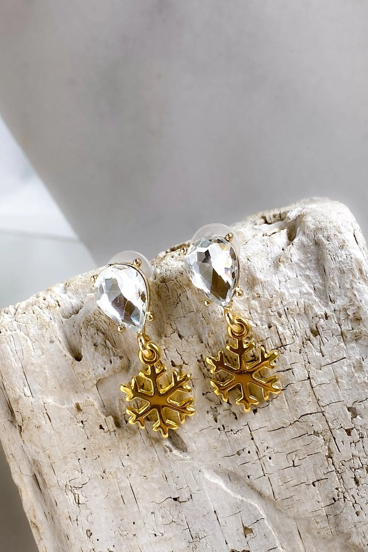Gold Snowflake Earrings with gold-tone snowflake charms and clear faceted teardrop crystals above each charm