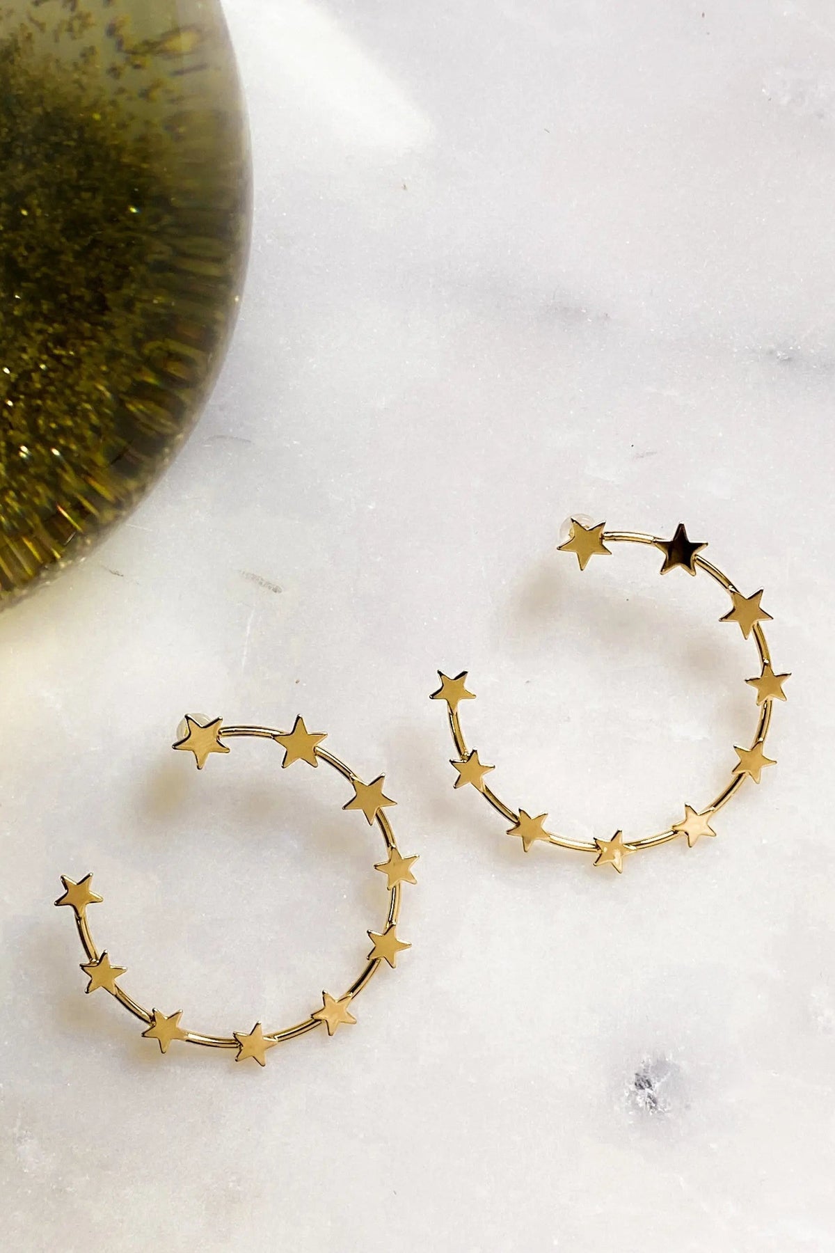 Gold Star Earring hoops in gold-toned metal, formed by delicate open circles with small star charms