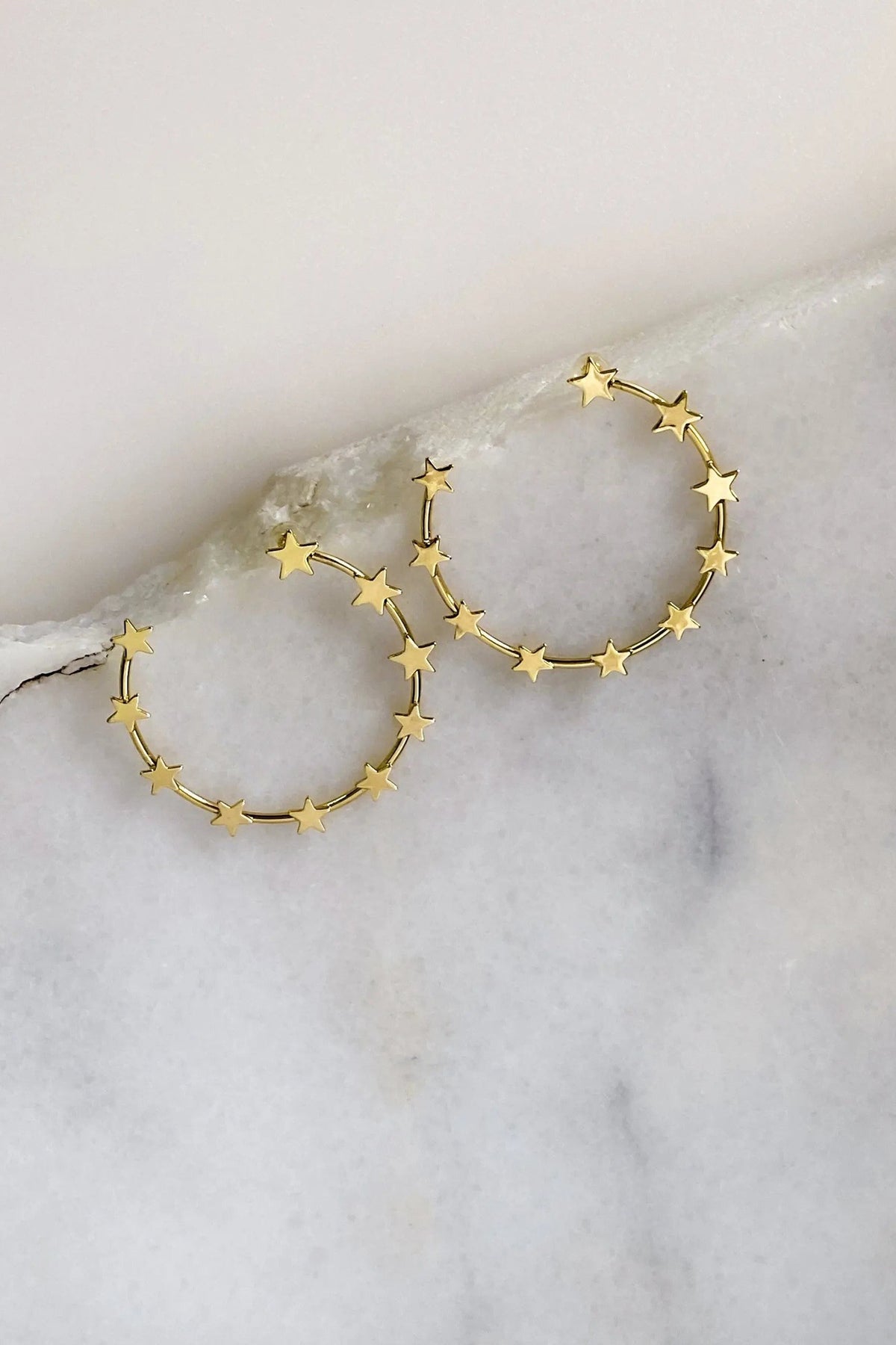 Gold Star Earring hoops in gold-tone metal, featuring delicate star charms spaced around thin circular hoops.
