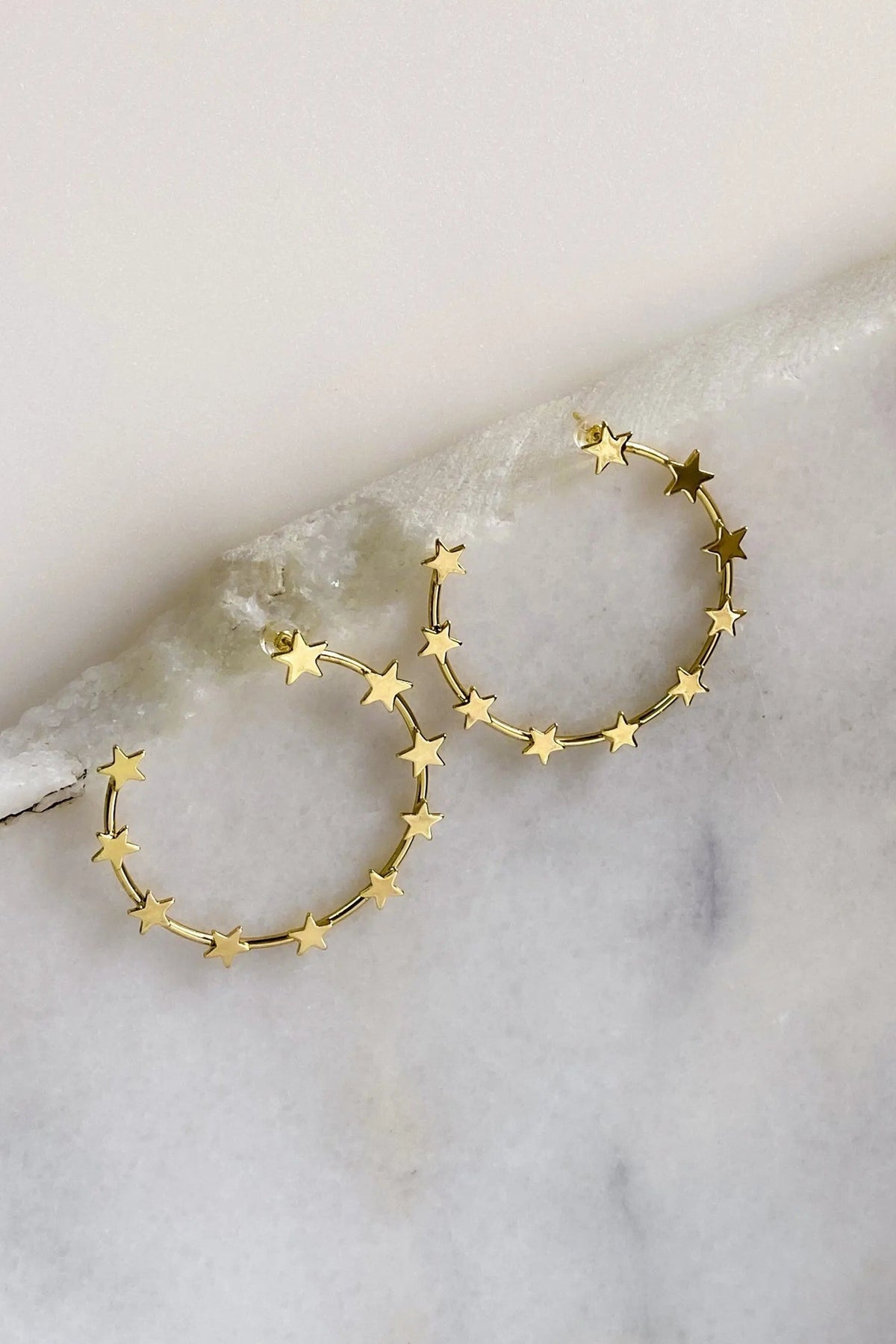Gold Star Earring hoops in gold-tone metal, featuring delicate star charms spaced around large circular hoops.