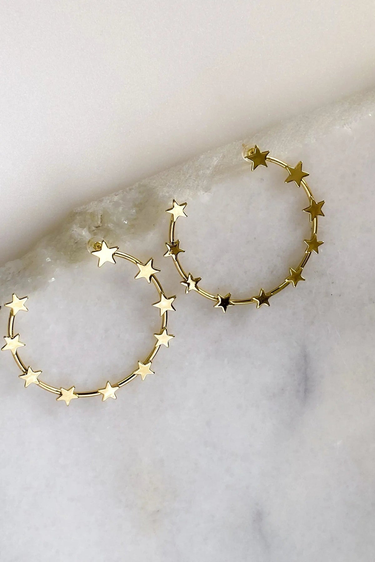 Gold Star Earring hoops in gold-tone metal, each ring decorated with small five-point stars along the curve.