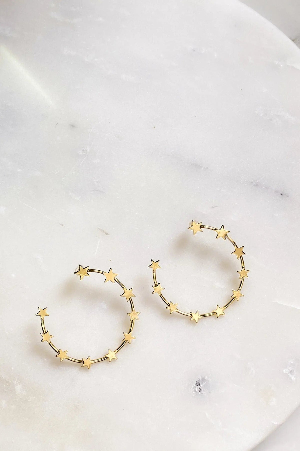 Gold Star Earring hoops in gold-tone metal, each decorated with small pointed stars around an open circular hoop.