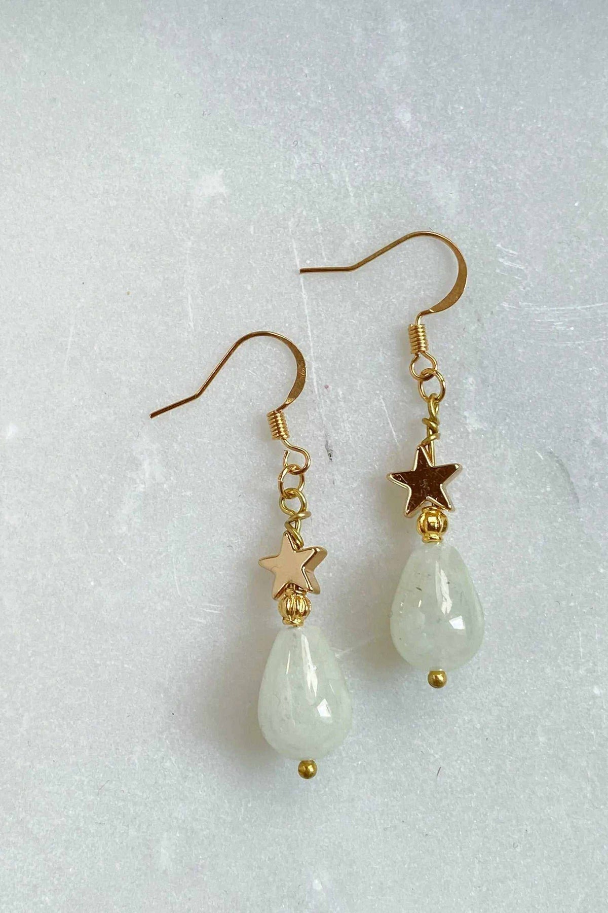 Gold star earrings with gold-toned star charms and pale green teardrop agate beads