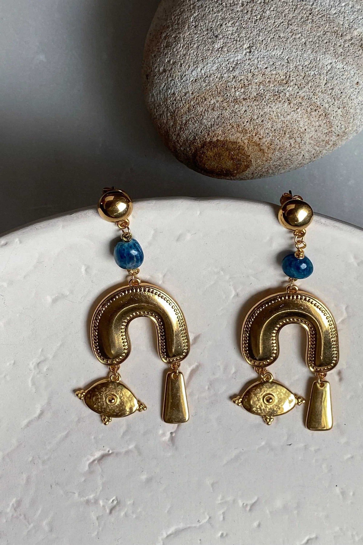 Gold Statement Earrings with blue round beads, polished gold-tone arches, eye-shaped charms and dangling tapered drops.