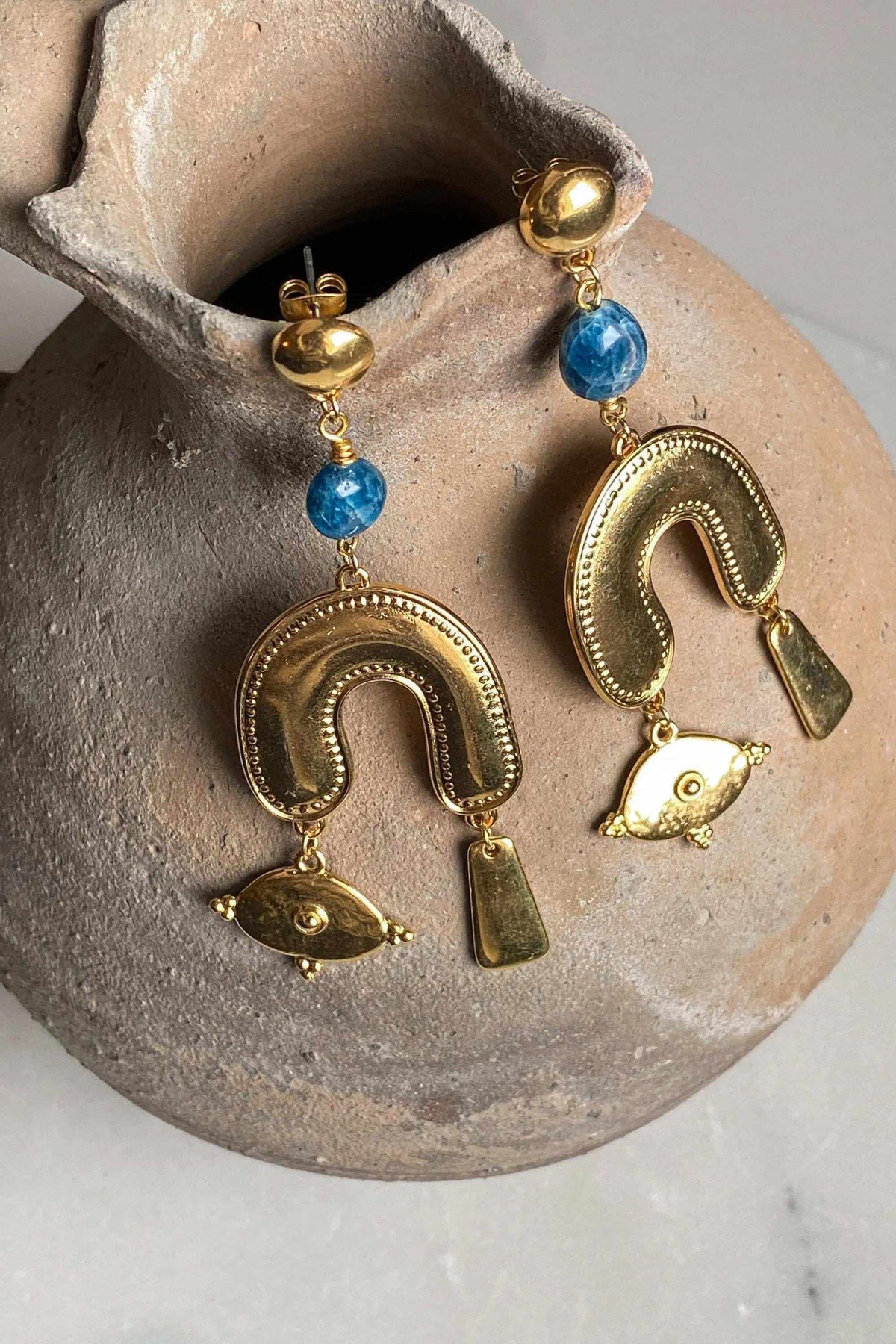 Gold Statement Earrings with ornate gold-tone metal, bright blue beads and dangling eye-shaped charms in a curved design