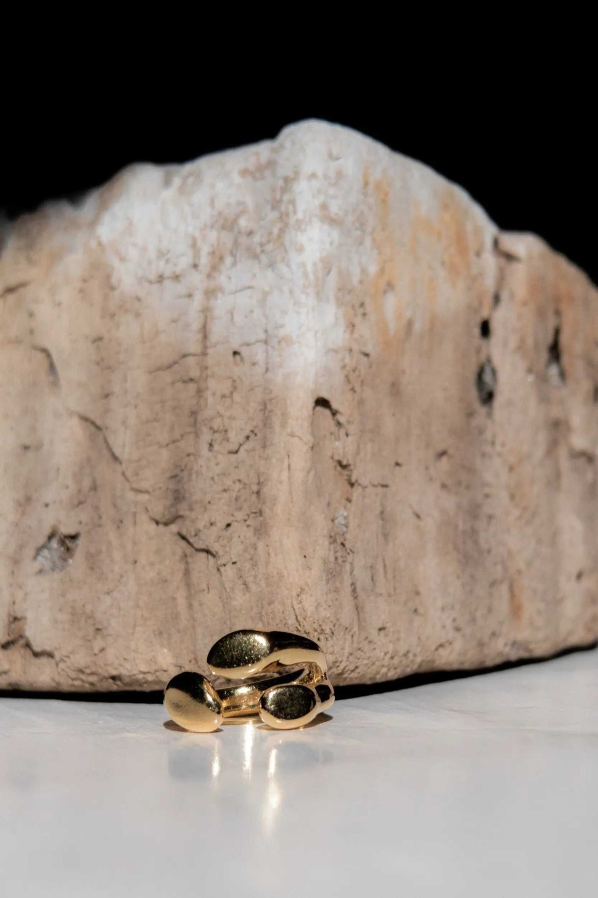 Greek Olive leaf ring in polished gold-tone metal, featuring a sculptural open band with dark oval accents