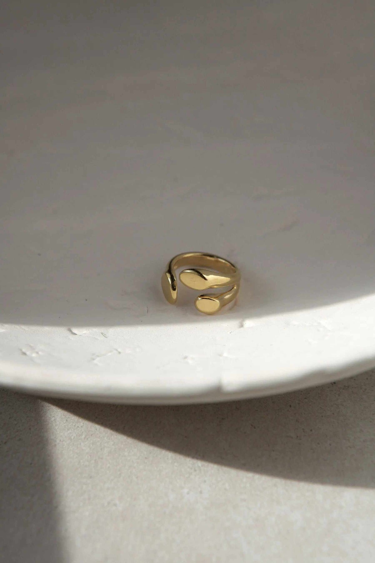 Greek Olive leaf ring in polished gold-tone metal, featuring an open adjustable band with sculpted leaf-like curves