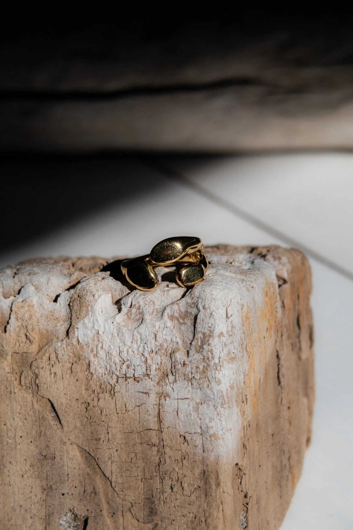 Greek Olive leaf ring in gold-tone metal with a sculptural cluster of dark oval leaf-shaped details