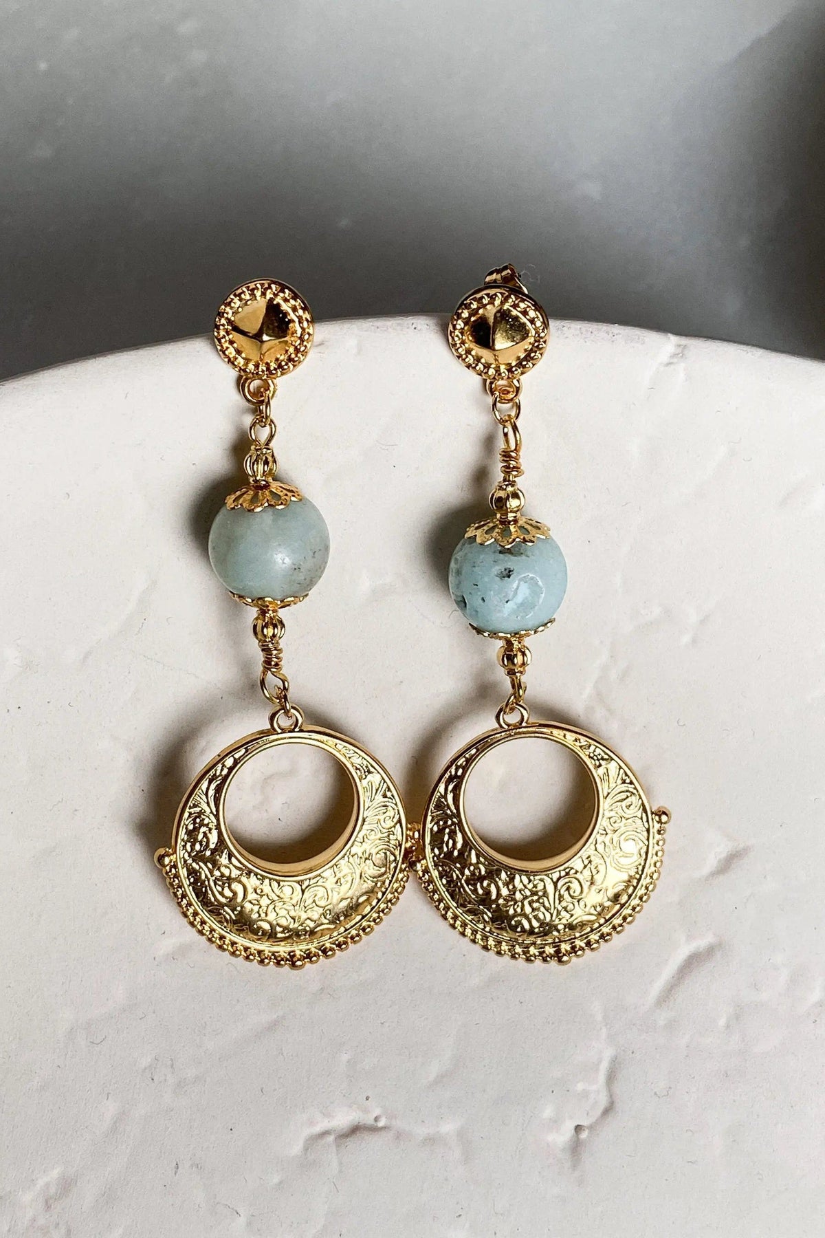 Gypsy gold Earrings with ornate gold-tone circular drops, pale blue beads and engraved crescent-shaped filigree pendants