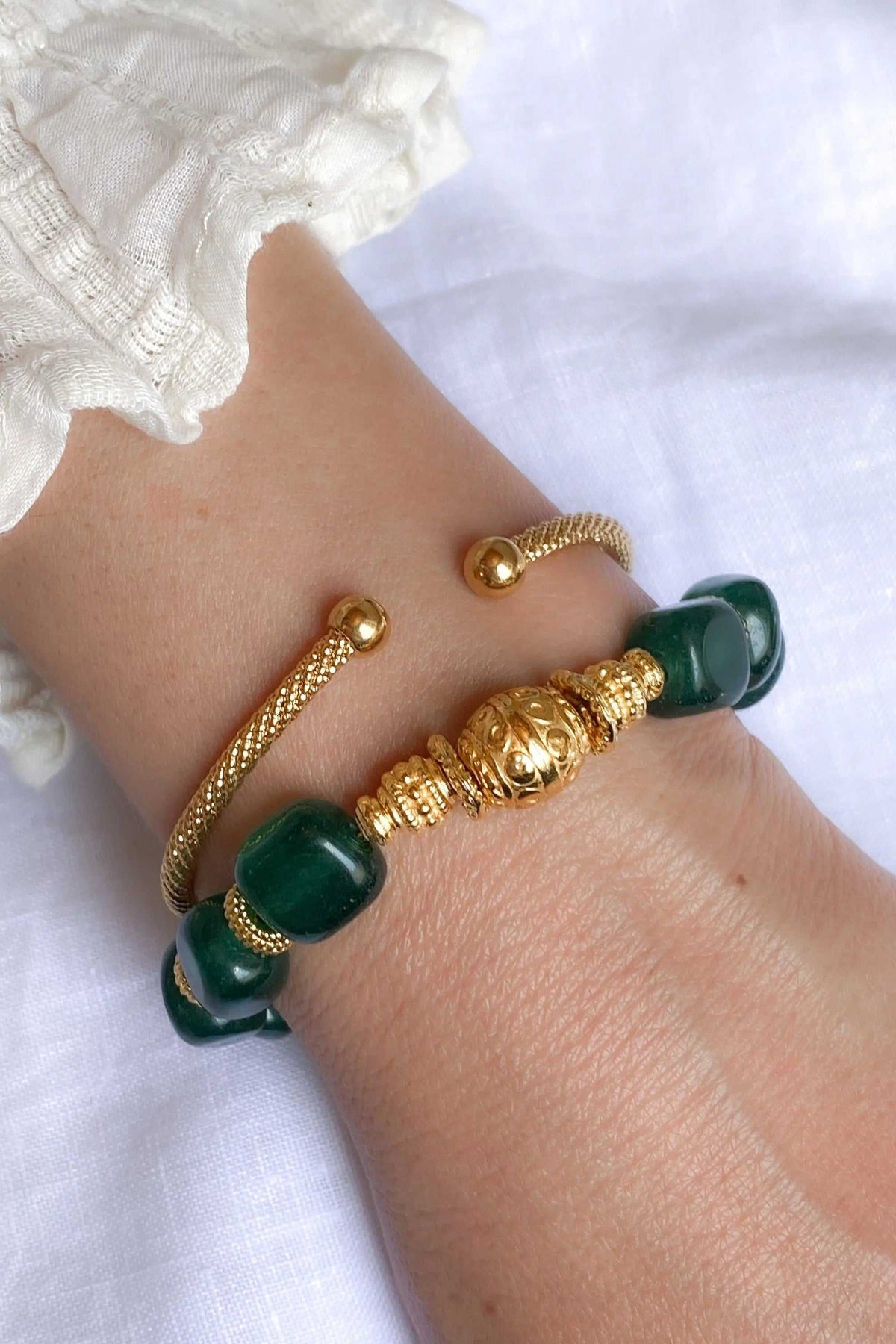 Healing Crystal Bracelet with deep green jade beads, gold-tone braided brass and ornate central bead on an open cuff