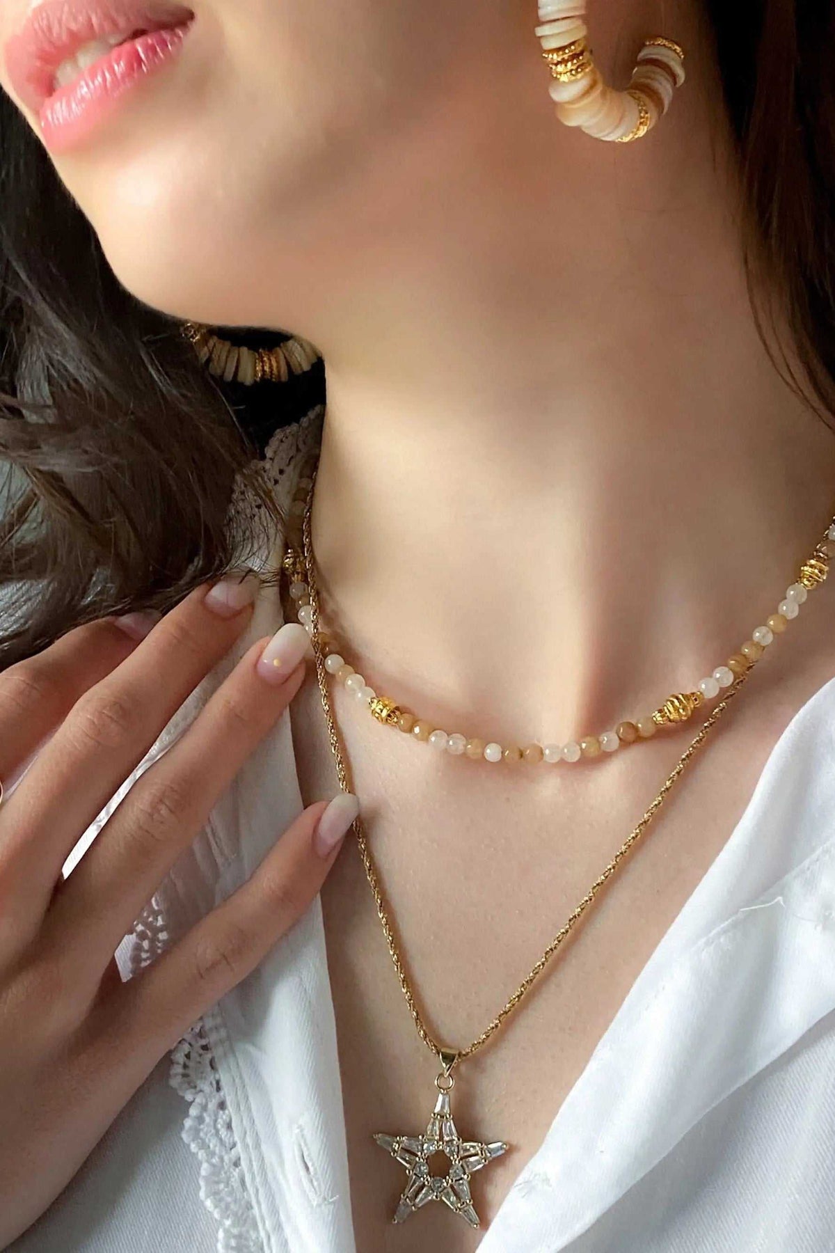Heishi Bead Necklace with cream and amber beads, gold accents, and layered star pendant detail