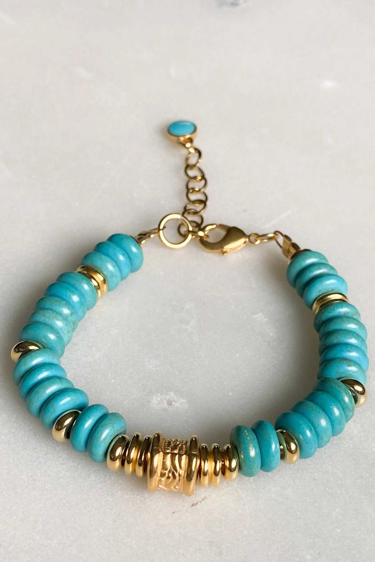 Heishi howlite beads bracelet with turquoise blue disc beads, gold-tone spacers and decorative gold centerpiece