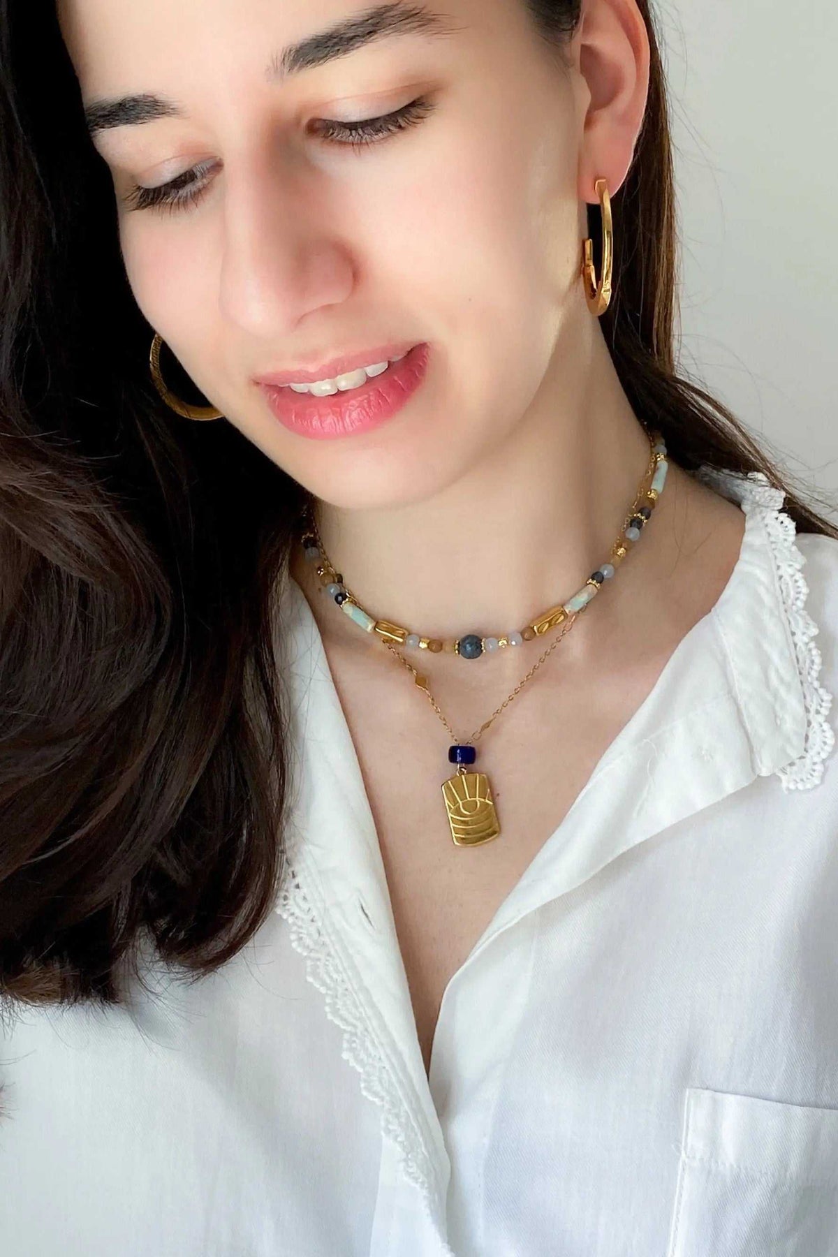Heishi Necklace with blue and white beads, gold accents, and a central blue pendant detail