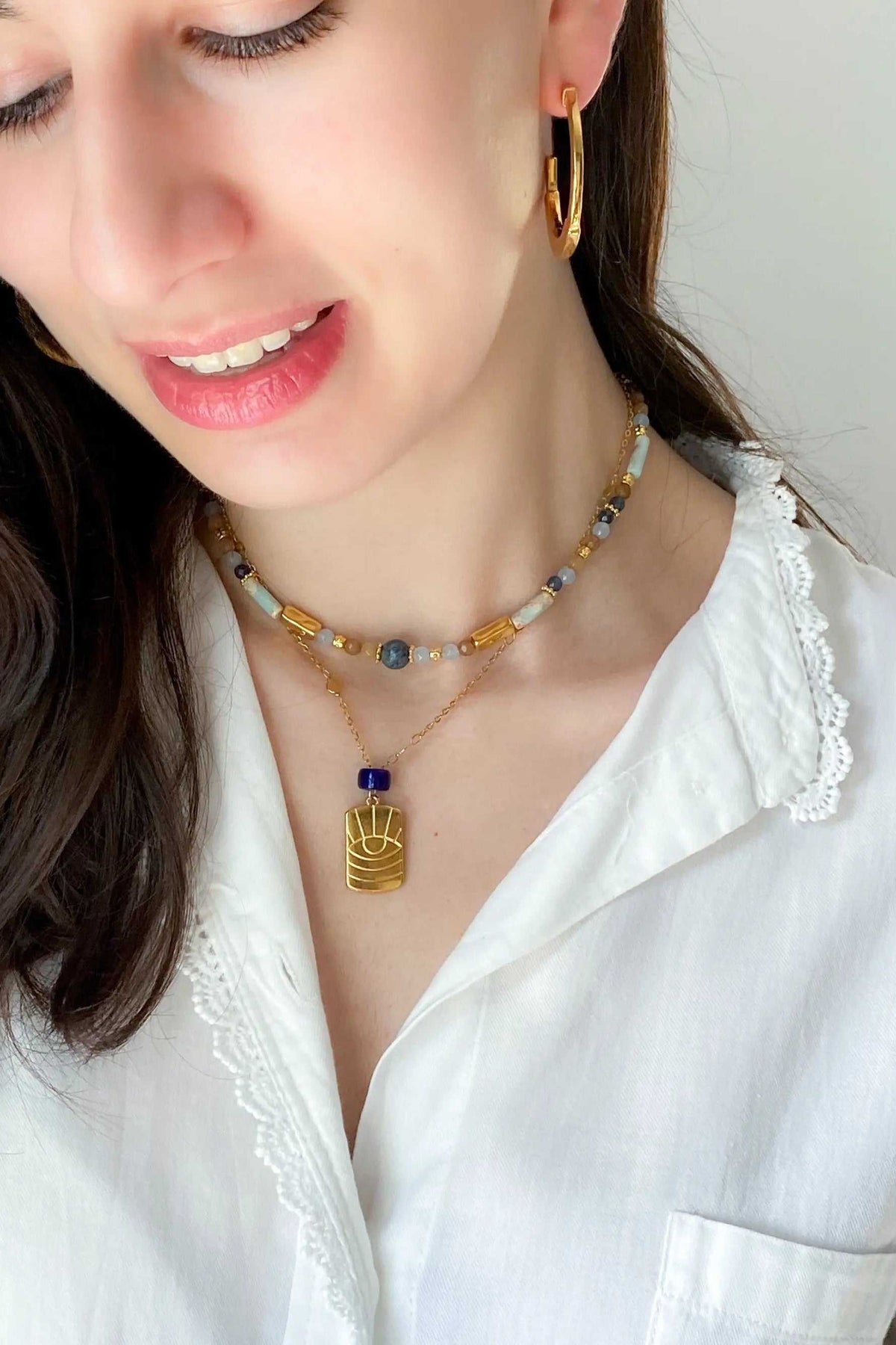 Heishi Necklace with blue and white beads, gold accents, and a distinctive central blue bead charm