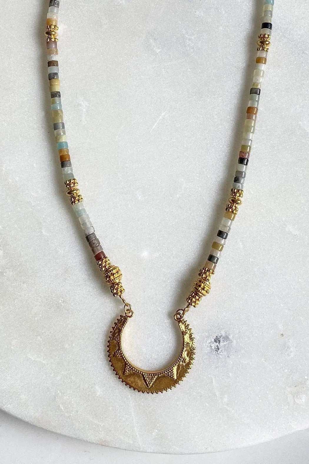 Heishi Necklace with slim multicoloured stone beads, gold accents and an ornate crescent-shaped pendant with triangular details