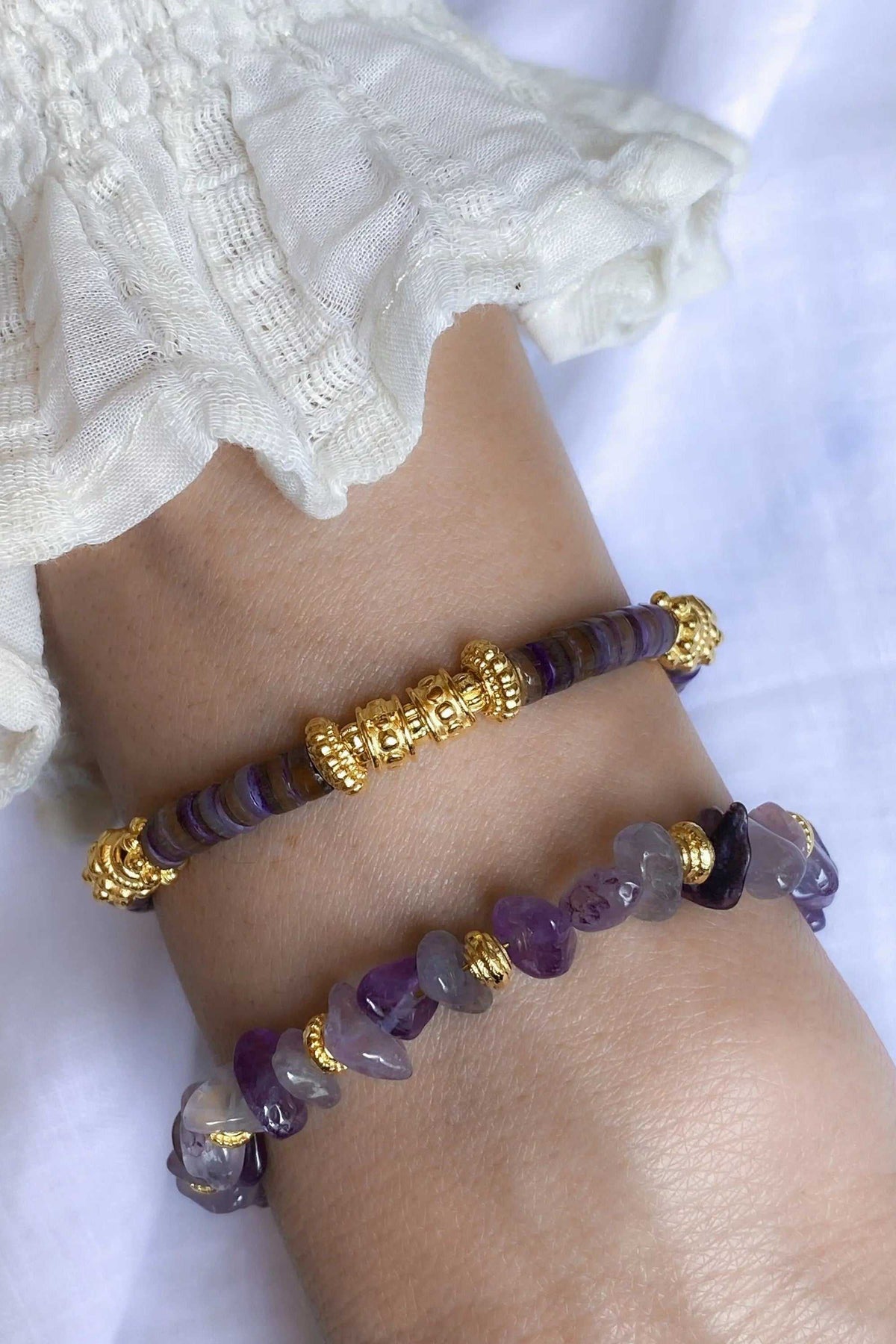Heishi shell beads bracelet with purple disc beads, irregular violet stones, and ornate gold-tone accents