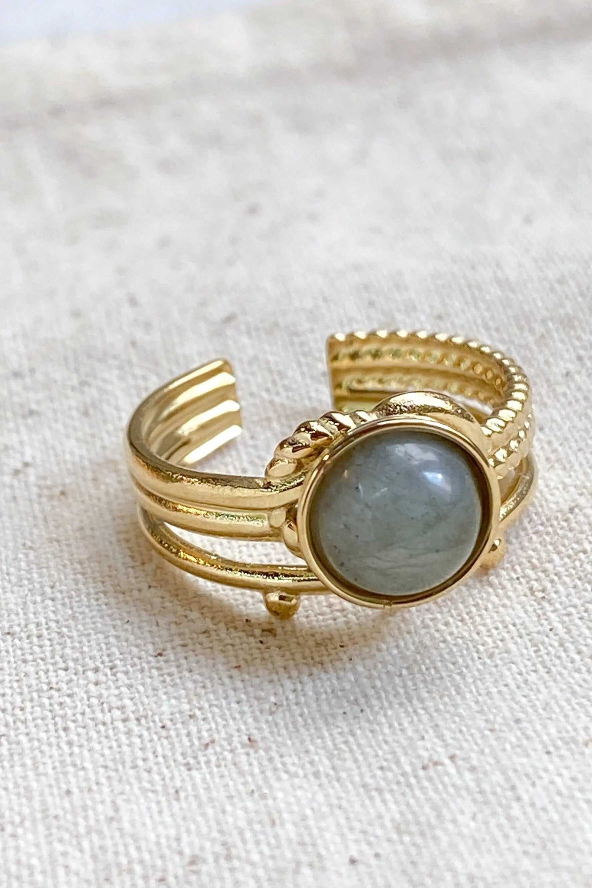 HERMINA Gold Stone Ring, a gold-toned adjustable band with a round grey stone and layered ridged details