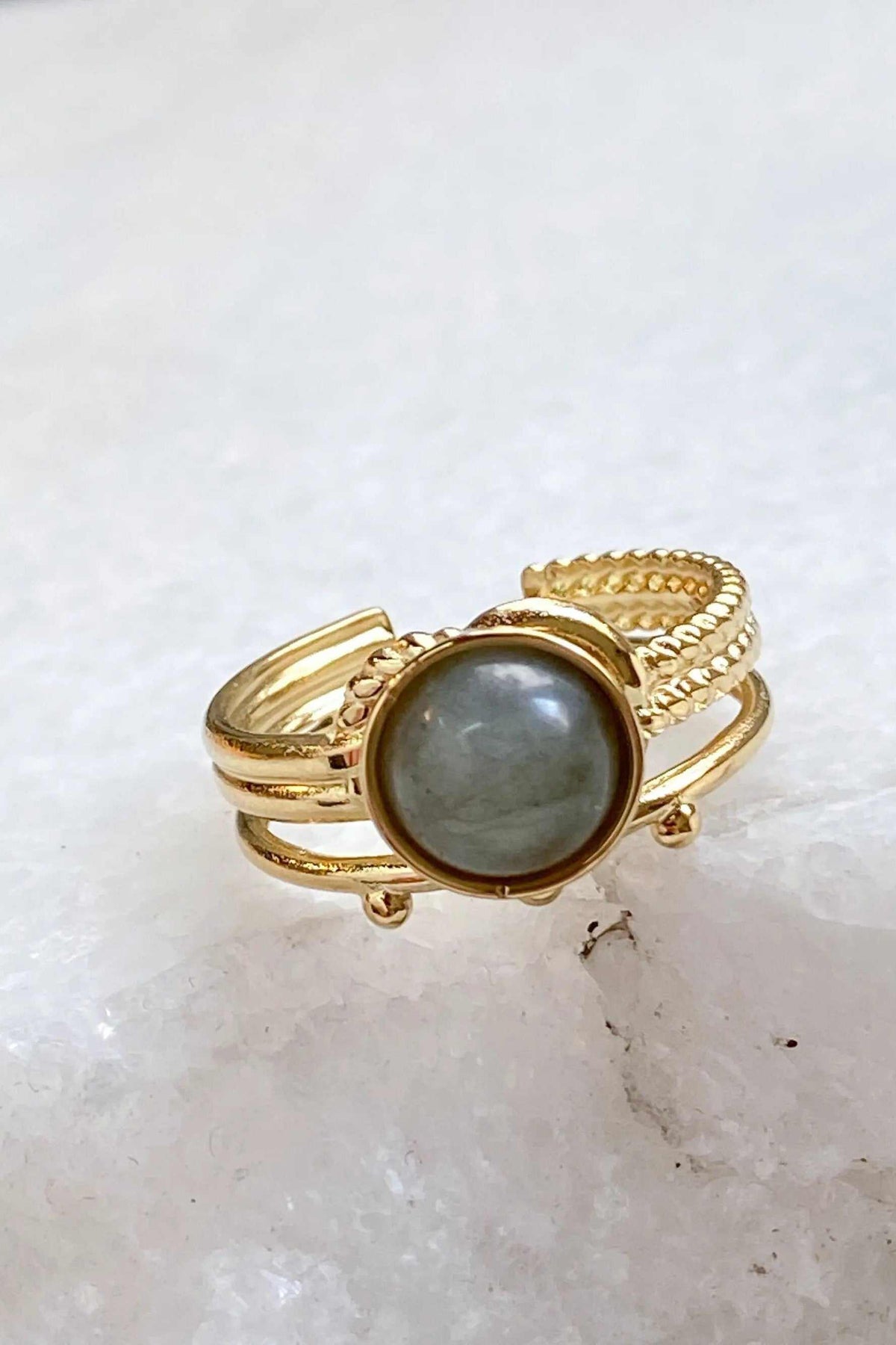 HERMINA Gold Stone Ring with a round grey stone set in a gold-tone band featuring twisted and ridged details