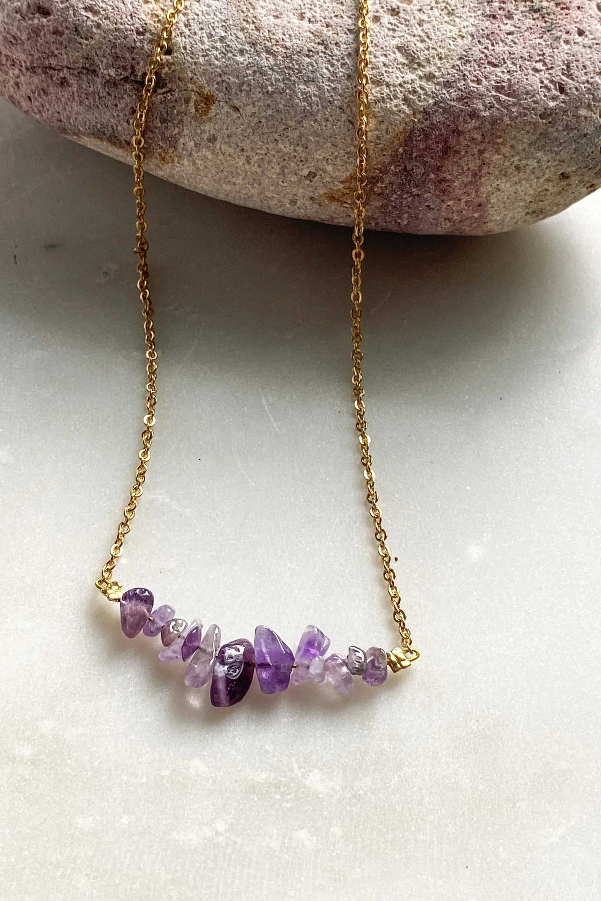 Hoop crystal earrings, a gold-tone fine chain necklace with a row of irregular purple and clear crystal chips