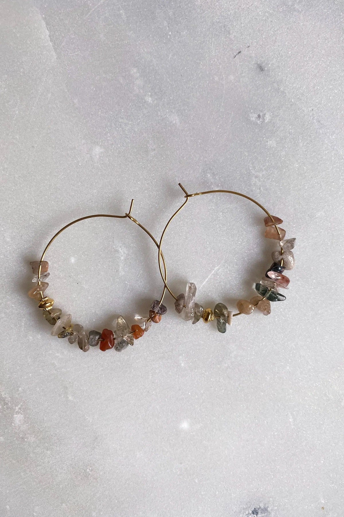 Hoop crystal earrings with thin gold-tone hoops and multicoloured natural stone chips arranged along the lower edges