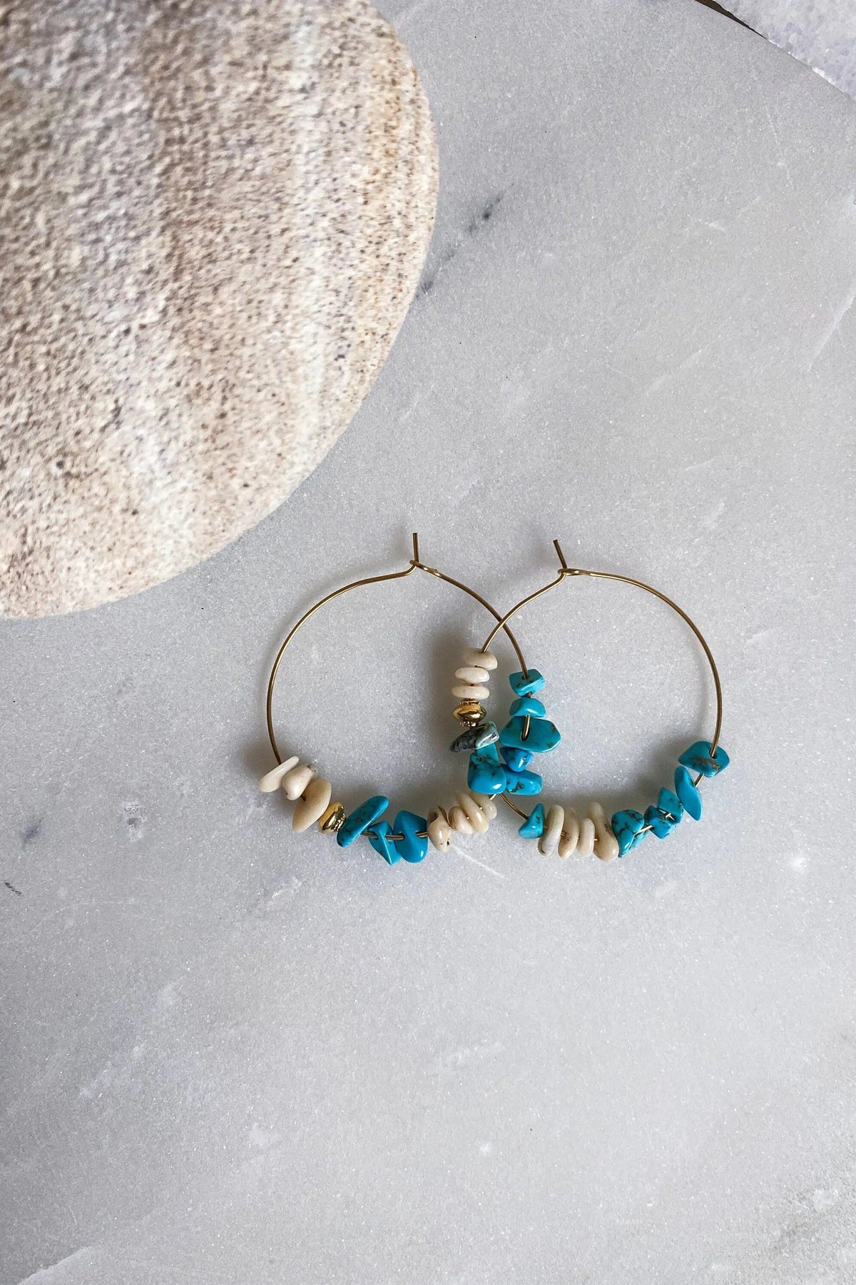 Hoop crystal earrings with thin gold-tone wire hoops and irregular turquoise-blue and ivory stone chips