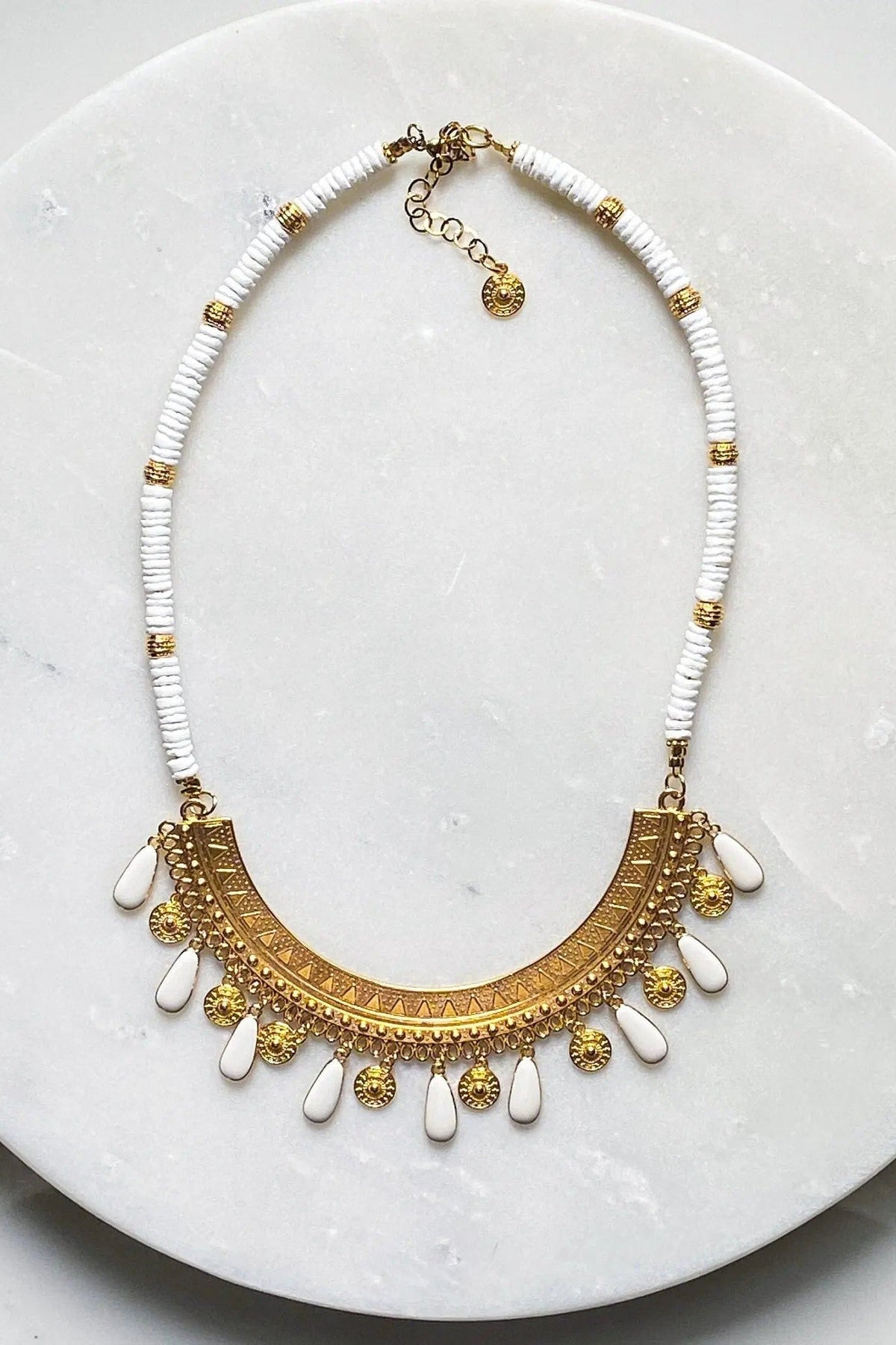 ILIADA NECKLACE with white shell beads, gold accents, and an ornate gold-plated pendant with enamel charms