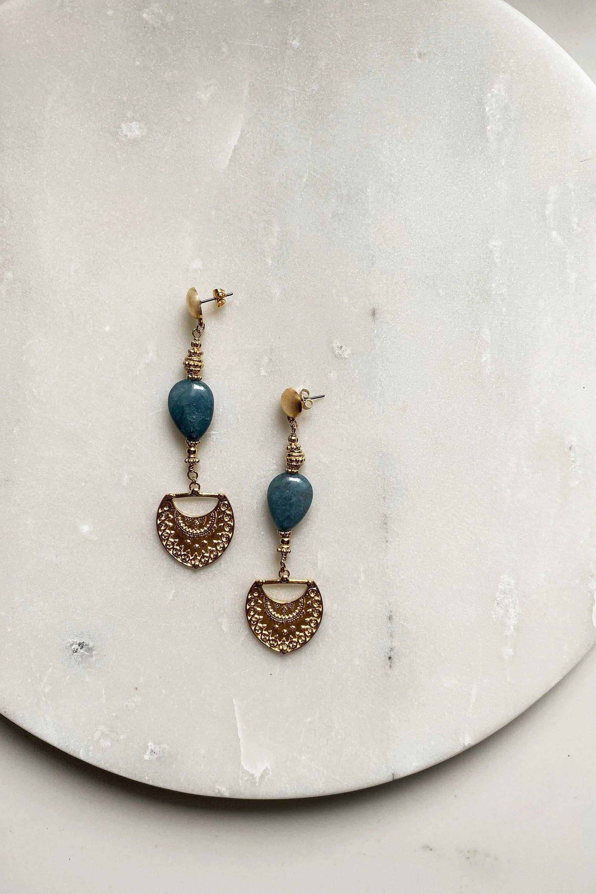 INÓ EARRINGS with blue oval stones and dangling gold-tone semicircular filigree charms on linked metal fittings