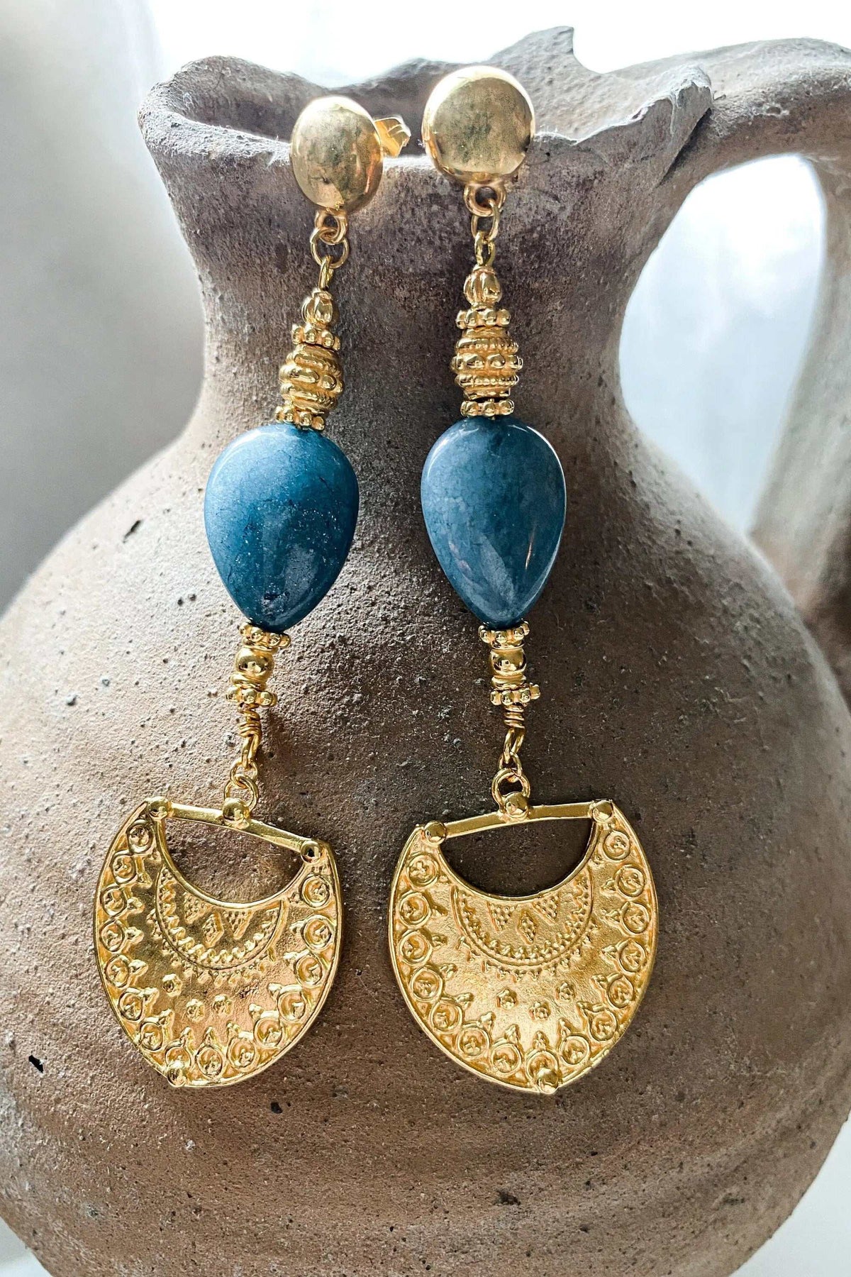 INÓ EARRINGS in gold-tone textured metal with blue teardrop stones and ornate shield-shaped dangling pendants