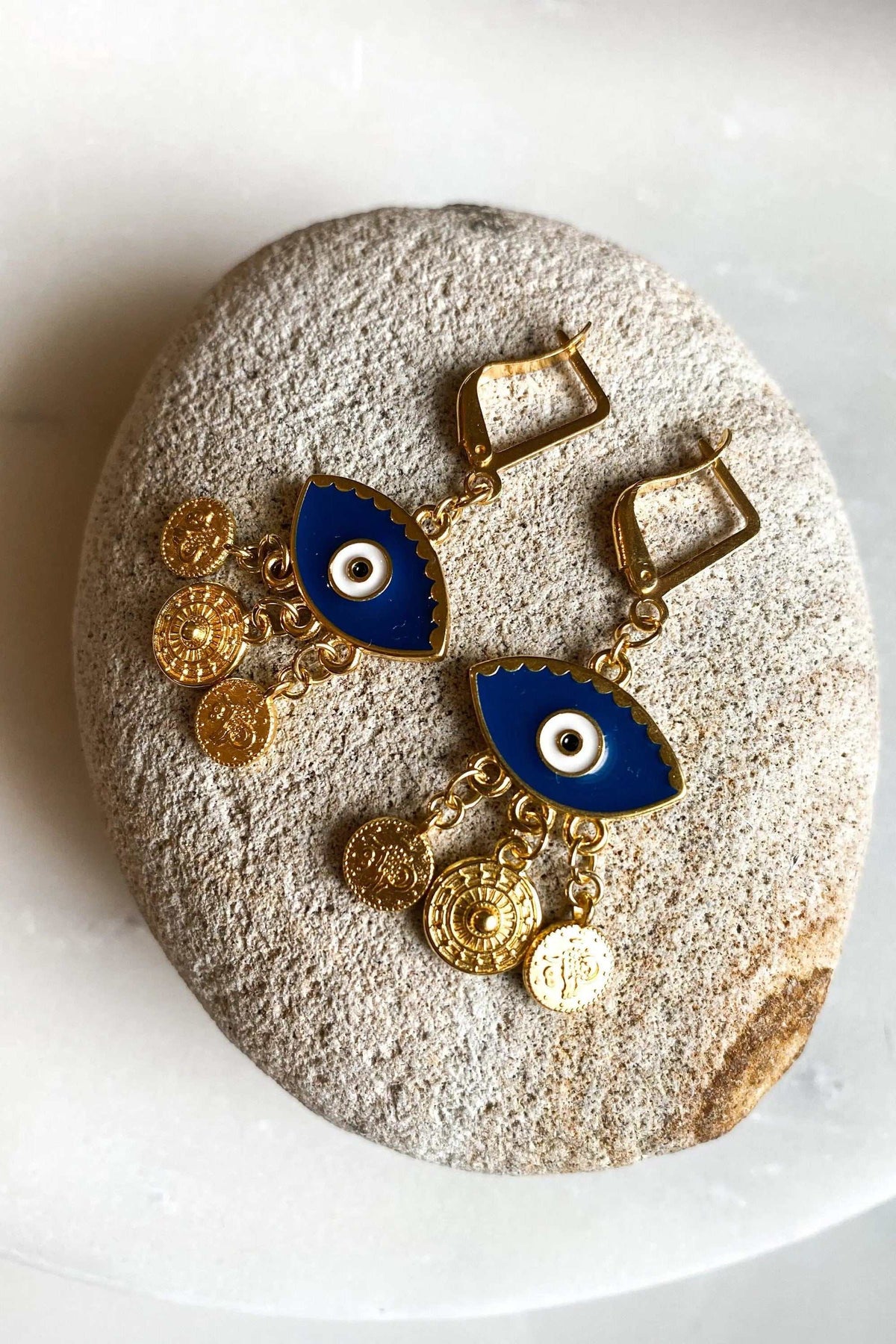 IOLI EARRINGS in gold-tone brass with blue enamel eye motifs and dangling textured coin charms