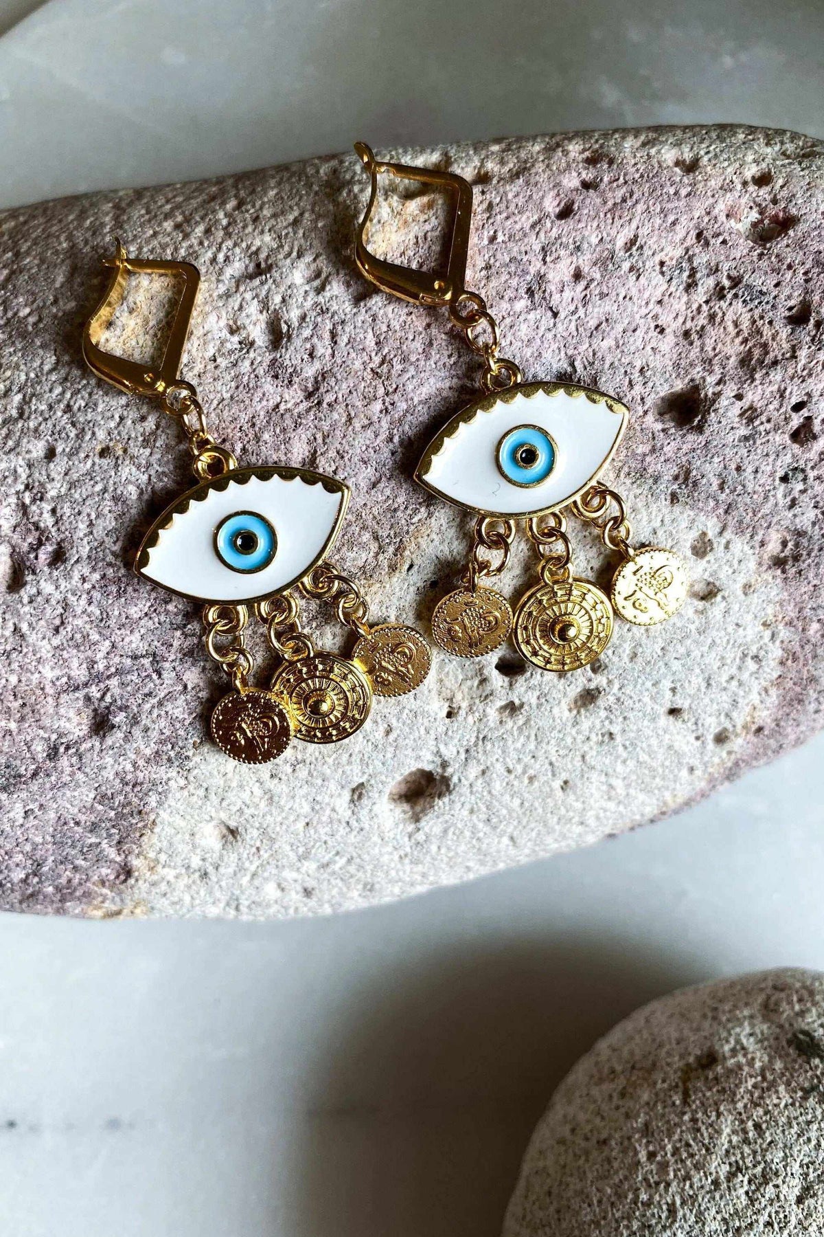 IOLI EARRINGS in gold-tone brass with white enamel blue eye motifs and dangling round coin charms