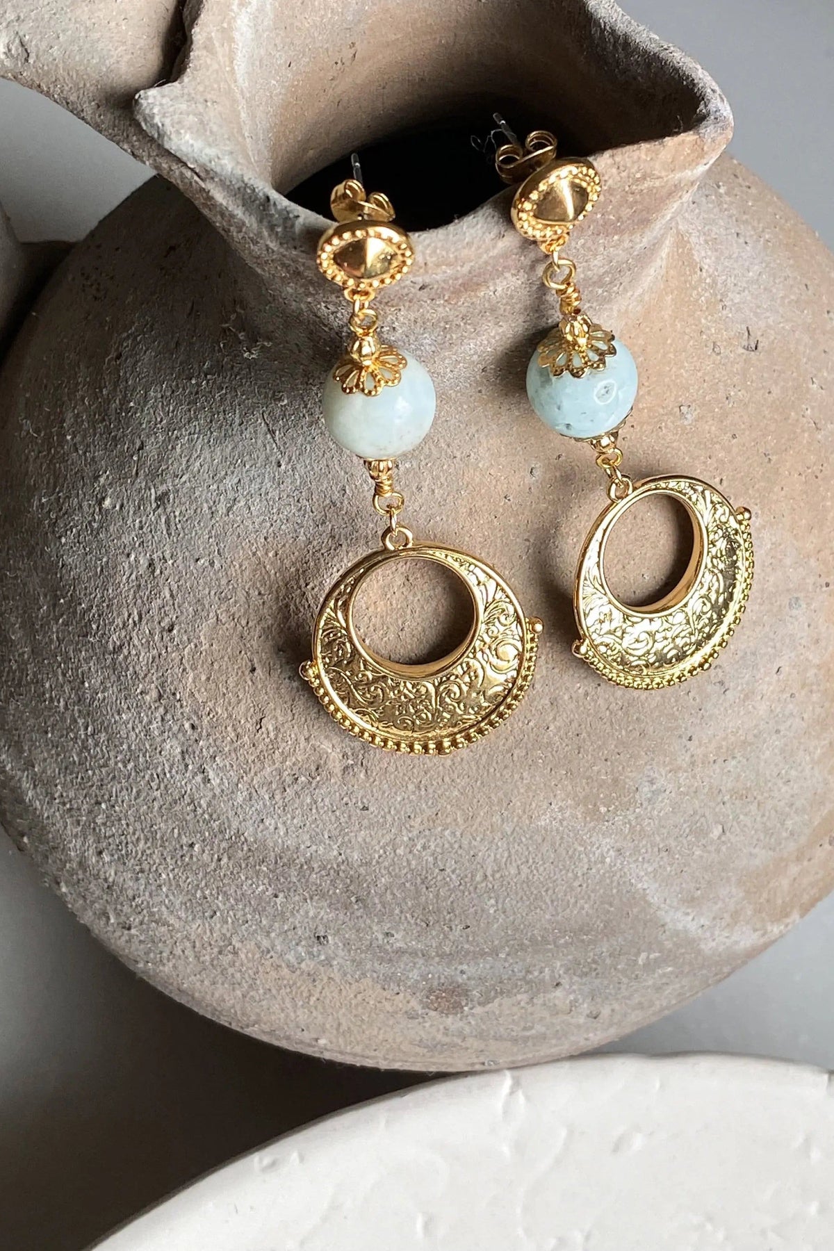 IRIS Amazonite Earrings feature pale blue round stones, ornate gold-tone metalwork and dangling circular medallions.