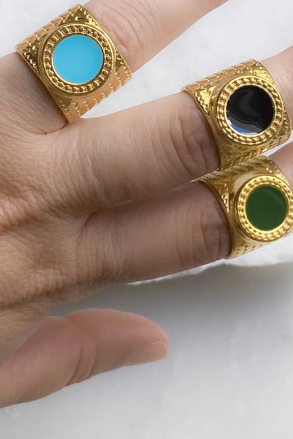 KARMI Gold wide band ring in textured gold with circular black resin stone and raised decorative bezel