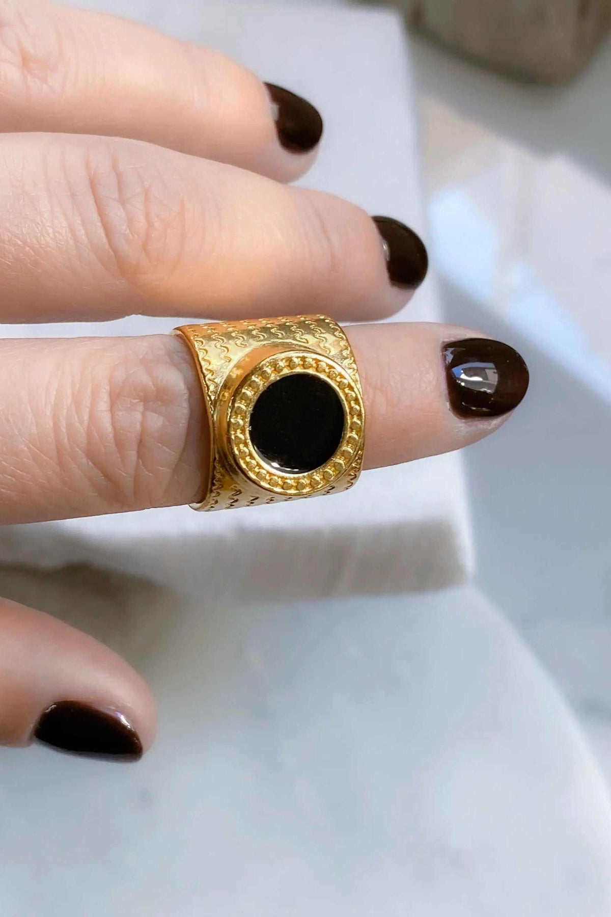 KARMI Gold wide band ring in textured gold with a round black resin stone and a raised beaded border