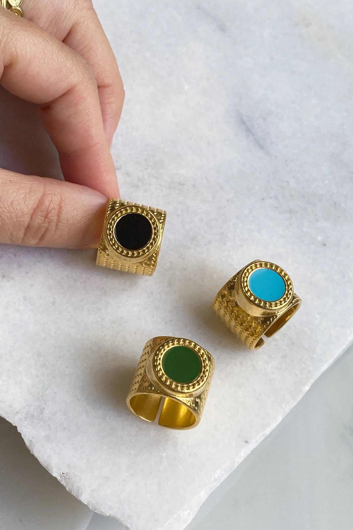 KARMI Gold wide band ring collection with textured gold-tone square bands set with round black, turquoise and green stones
