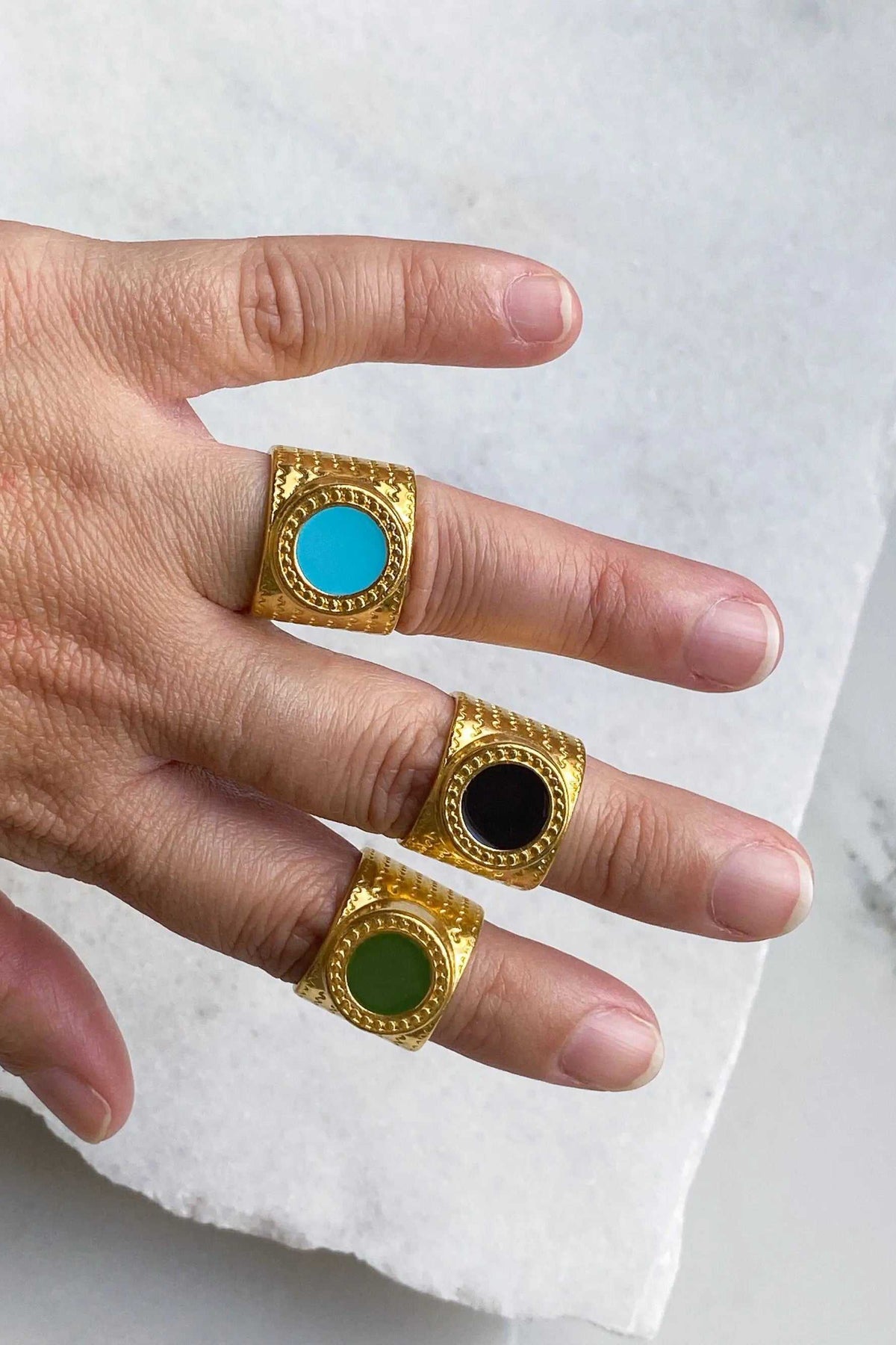 KARMI Gold wide band ring in gold-tone textured metal, shown with turquoise, black and green round resin stones